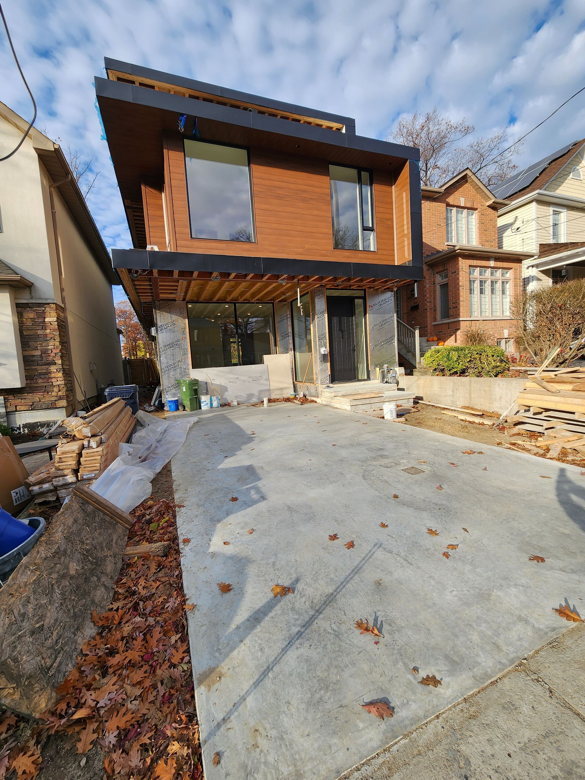 A large brick house with a concrete driveway in front of it.