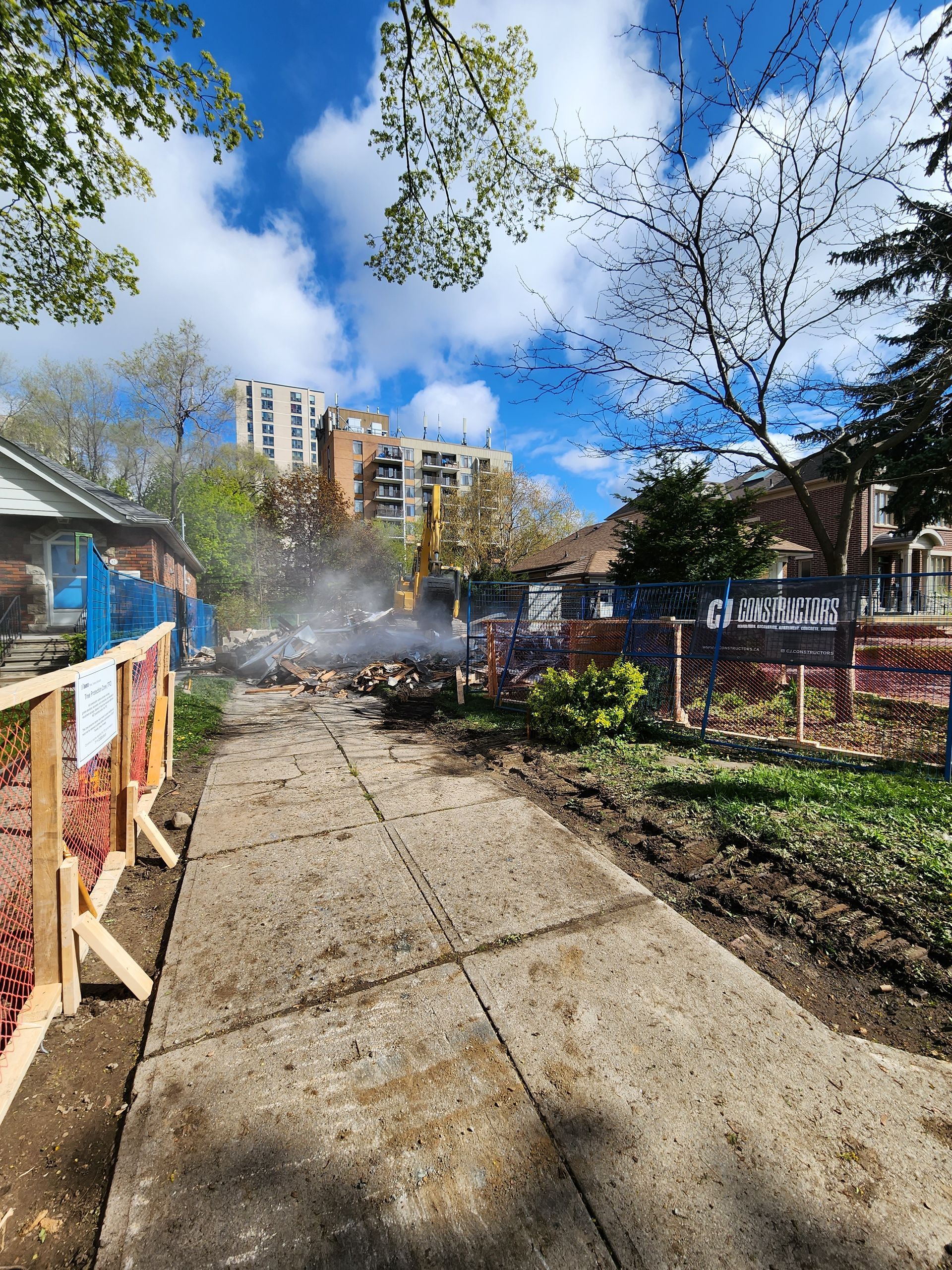 A concrete walkway with a wooden fence along the side of it.