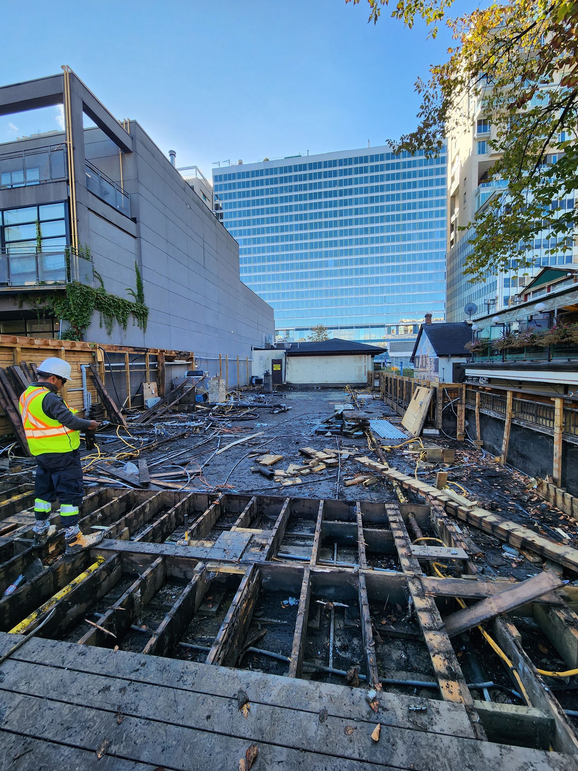 A construction worker is standing in the middle of a construction site.