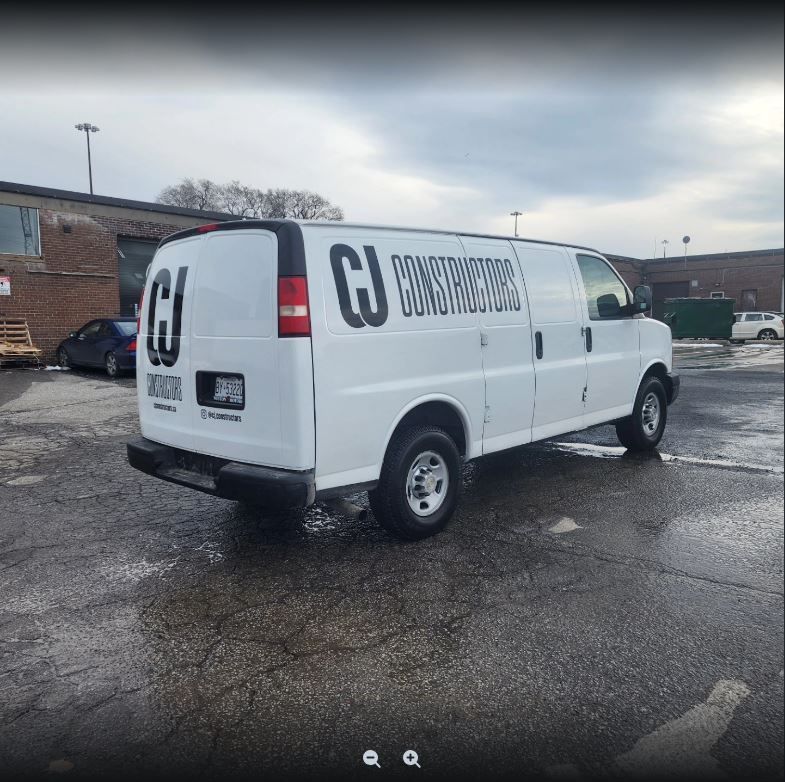A white van with the letters cj on the side is parked in a parking lot.
