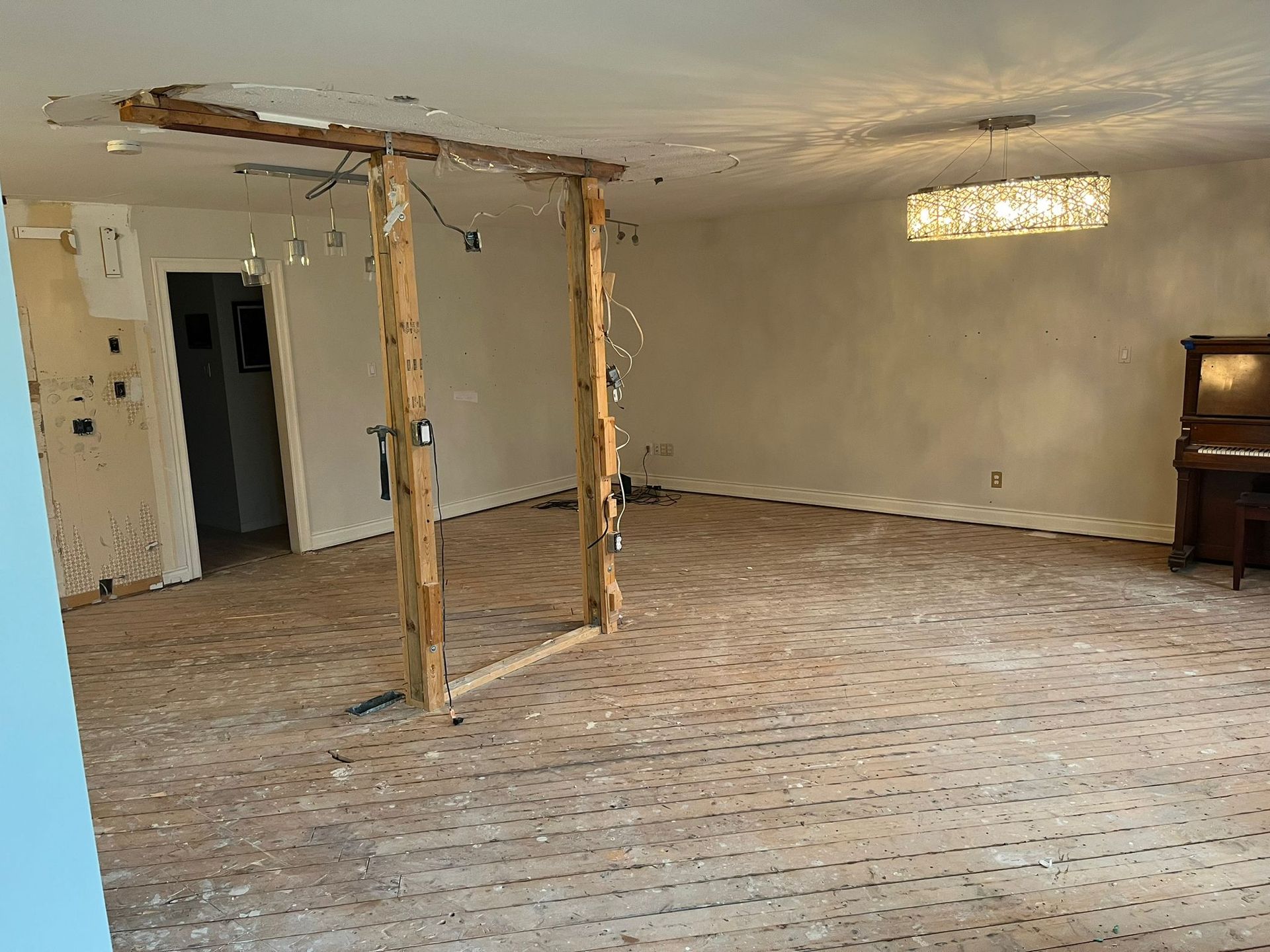 Room under renovation with exposed wood framing and ceiling damage.