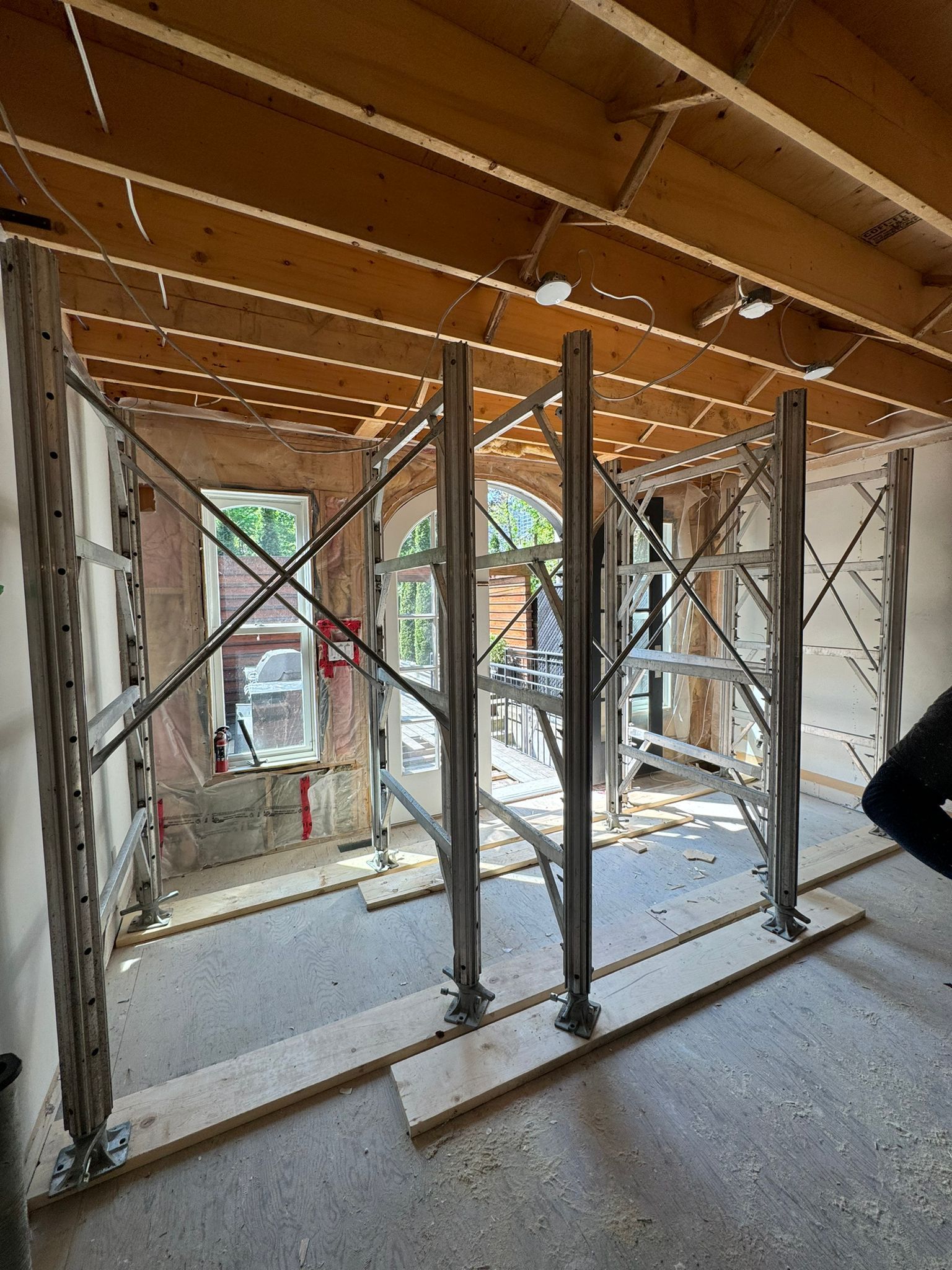 A room under construction with scaffolding and wooden beams.