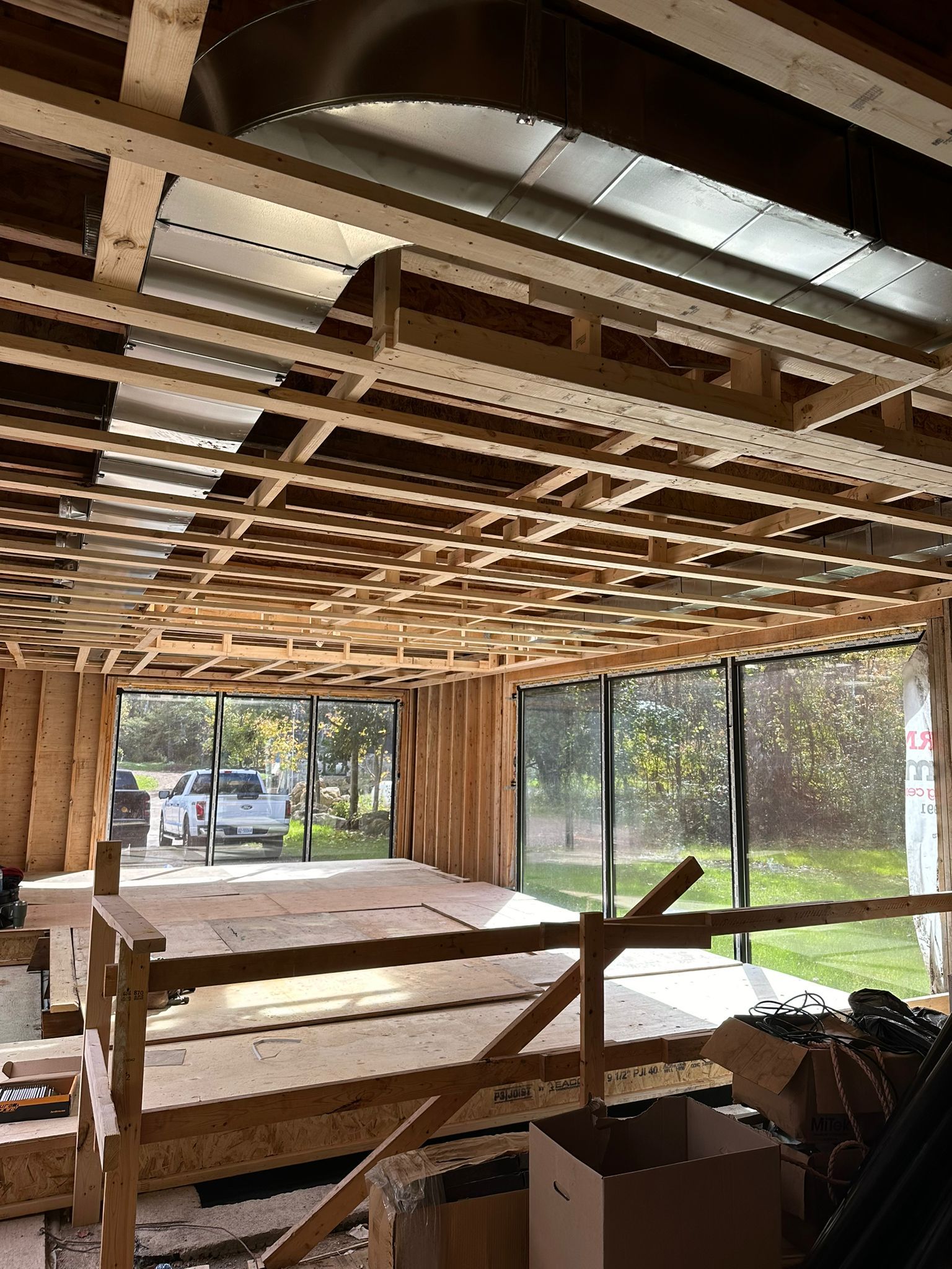 A room under construction with a lot of wood and a lot of windows.