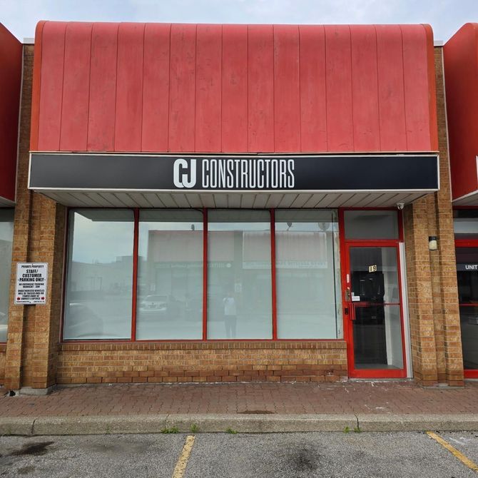 A building with a sign that says ' cj constructors ' on it