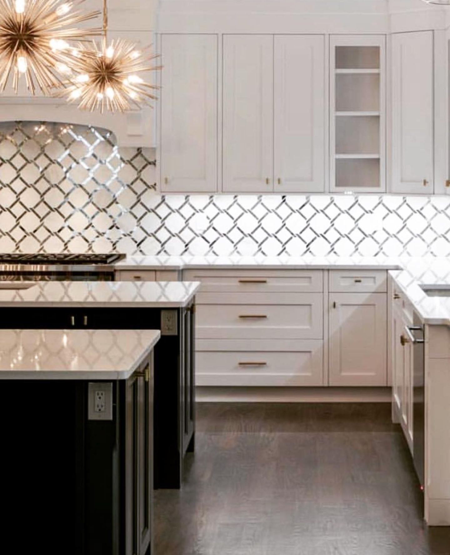 Modern kitchen with white cabinets, dark island, and decorative tile backsplash.