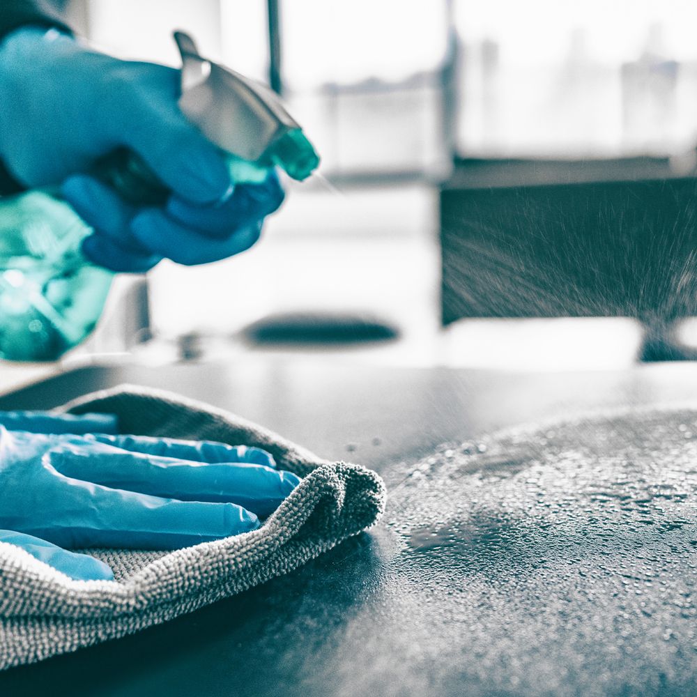 Professional Cleaner Sanitizing Office Desk