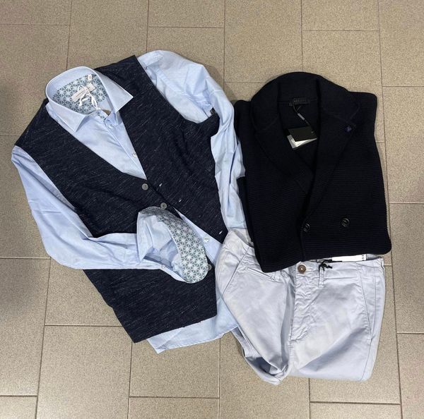 Abbigliamento maschile: gilet blu su camicia azzurra, gilet blu navy, pantaloni azzurri su pavimento piastrellato.