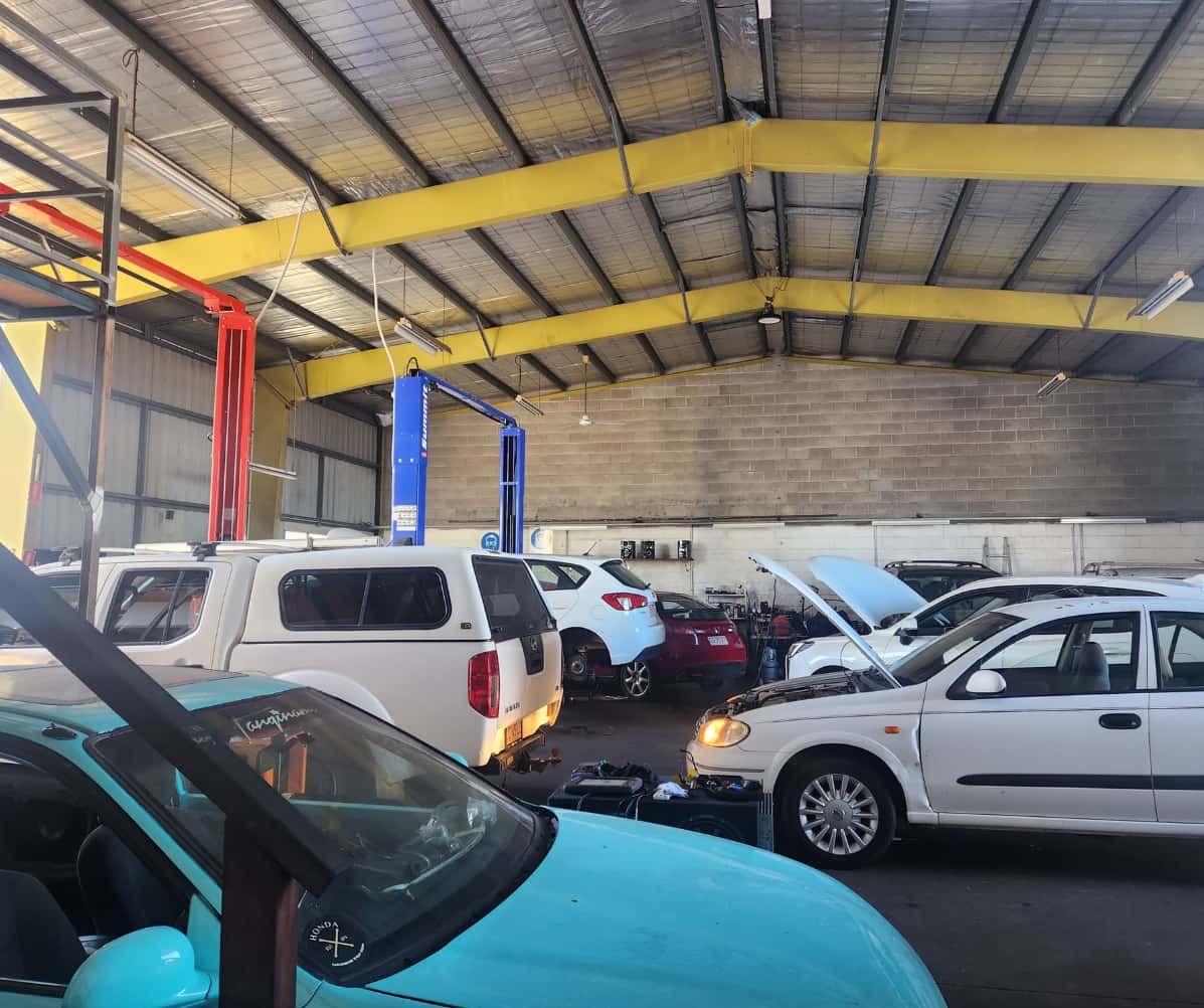 A Row of Cars Are Parked in a Garage — JDM Mechanical & Aircon Repairs In Coconut Grove, NT