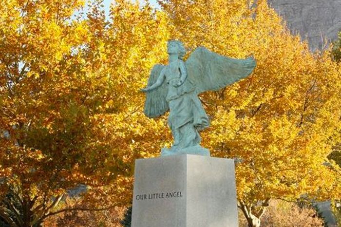 Statue on a pedestal with autumn-yellow trees in the background