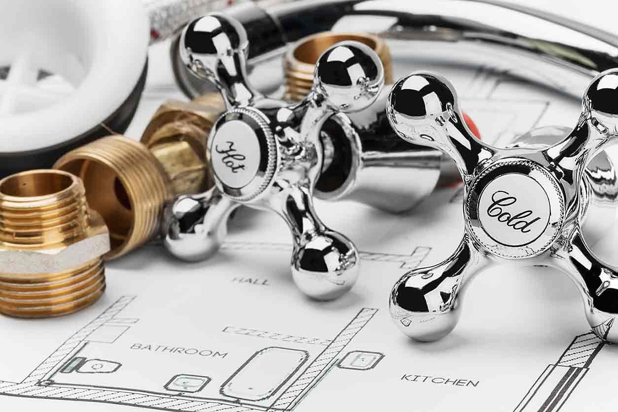 A close up of a plumbing faucet on top of a blueprint.