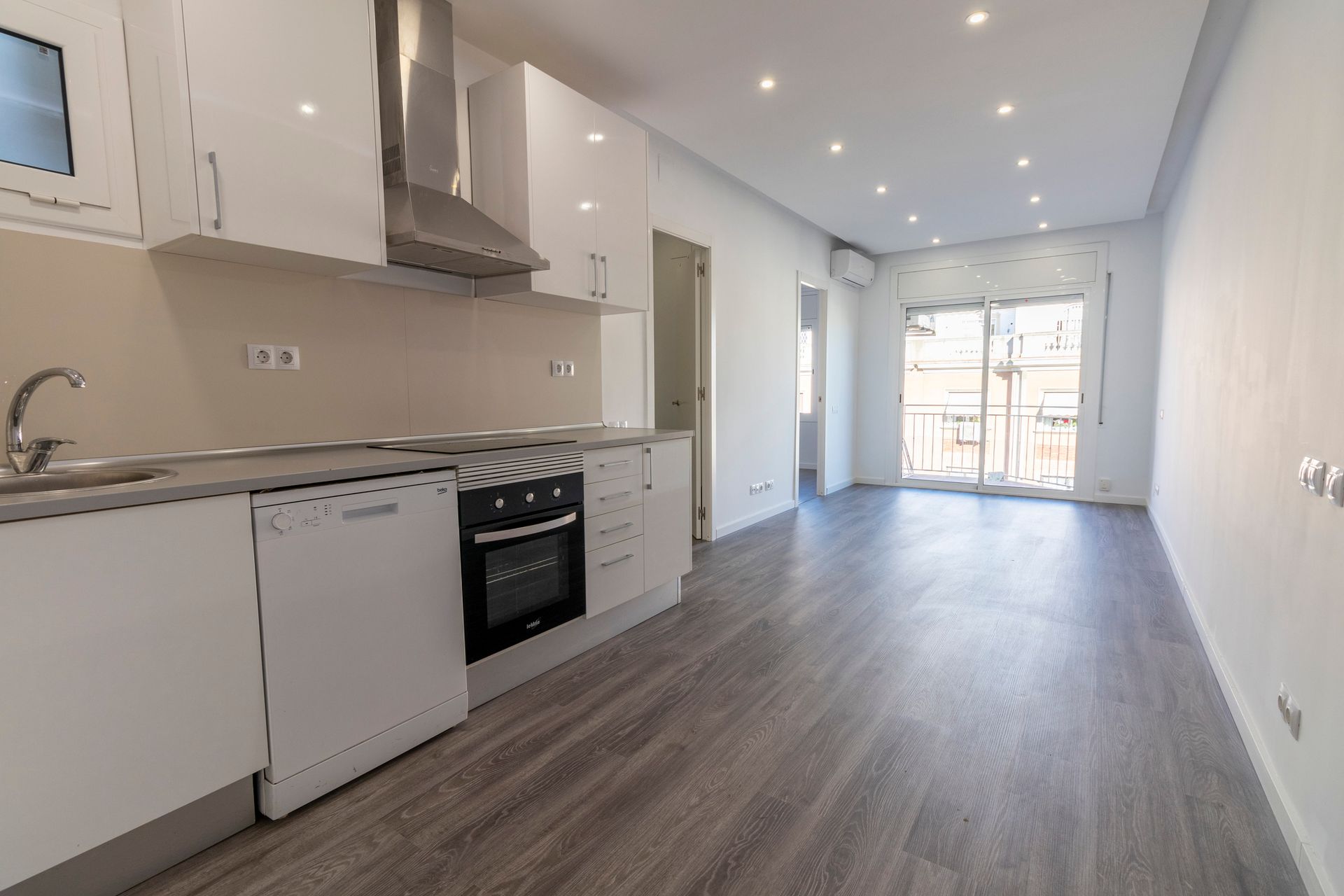 A kitchen with white cabinets , a stove , a sink , and a dishwasher.