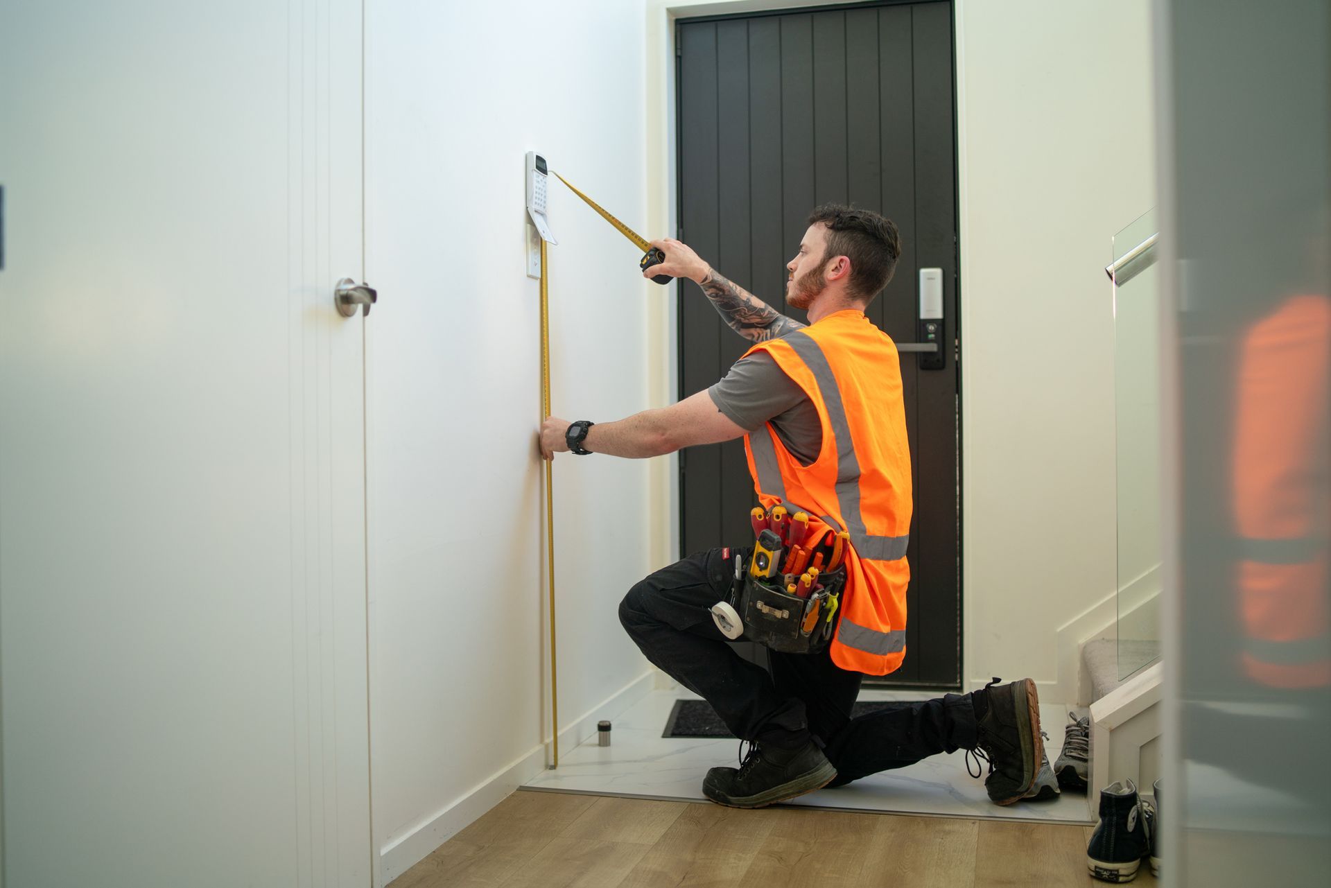 A man is measuring a door with a tape measure.