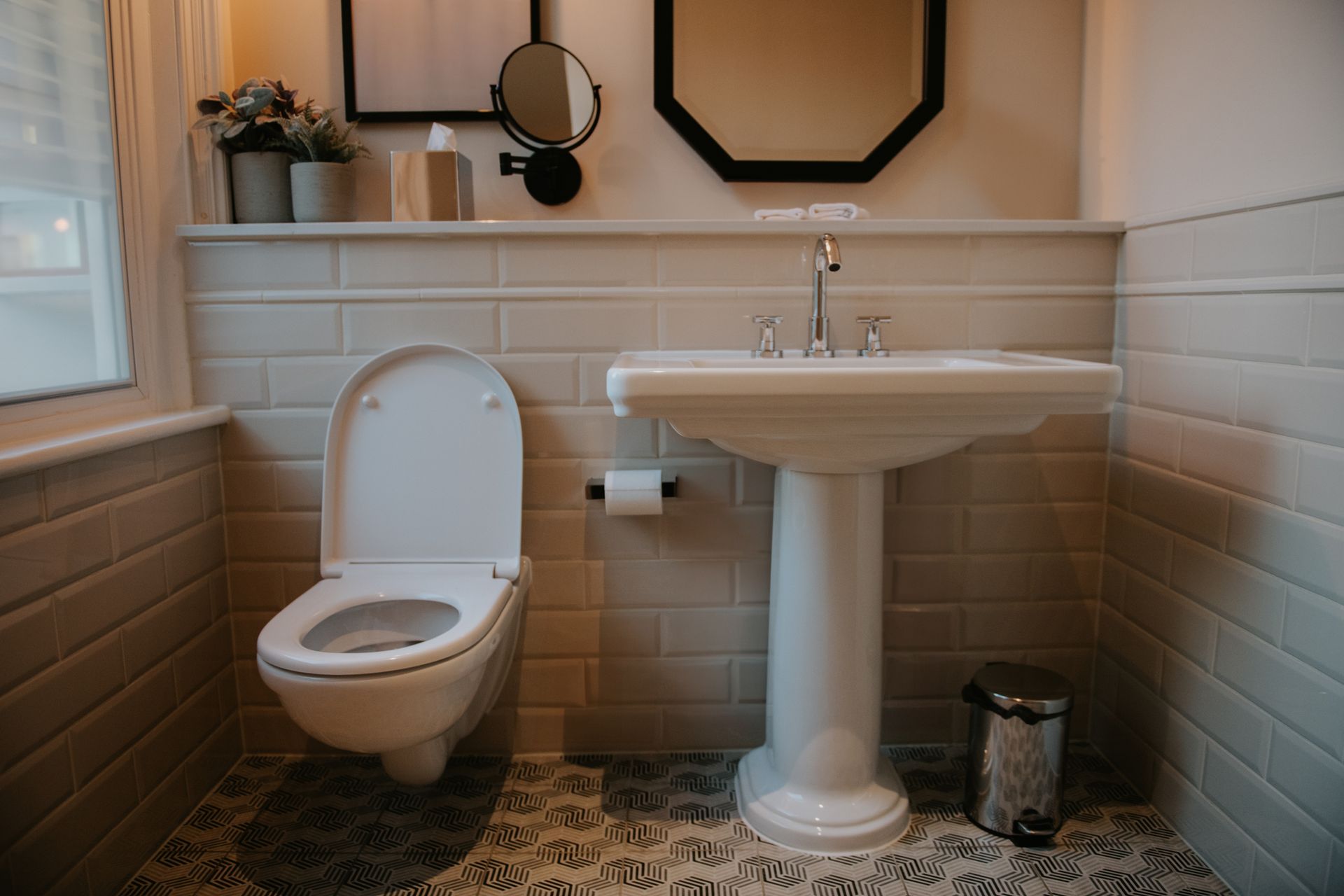 A bathroom with a toilet , sink and mirror.