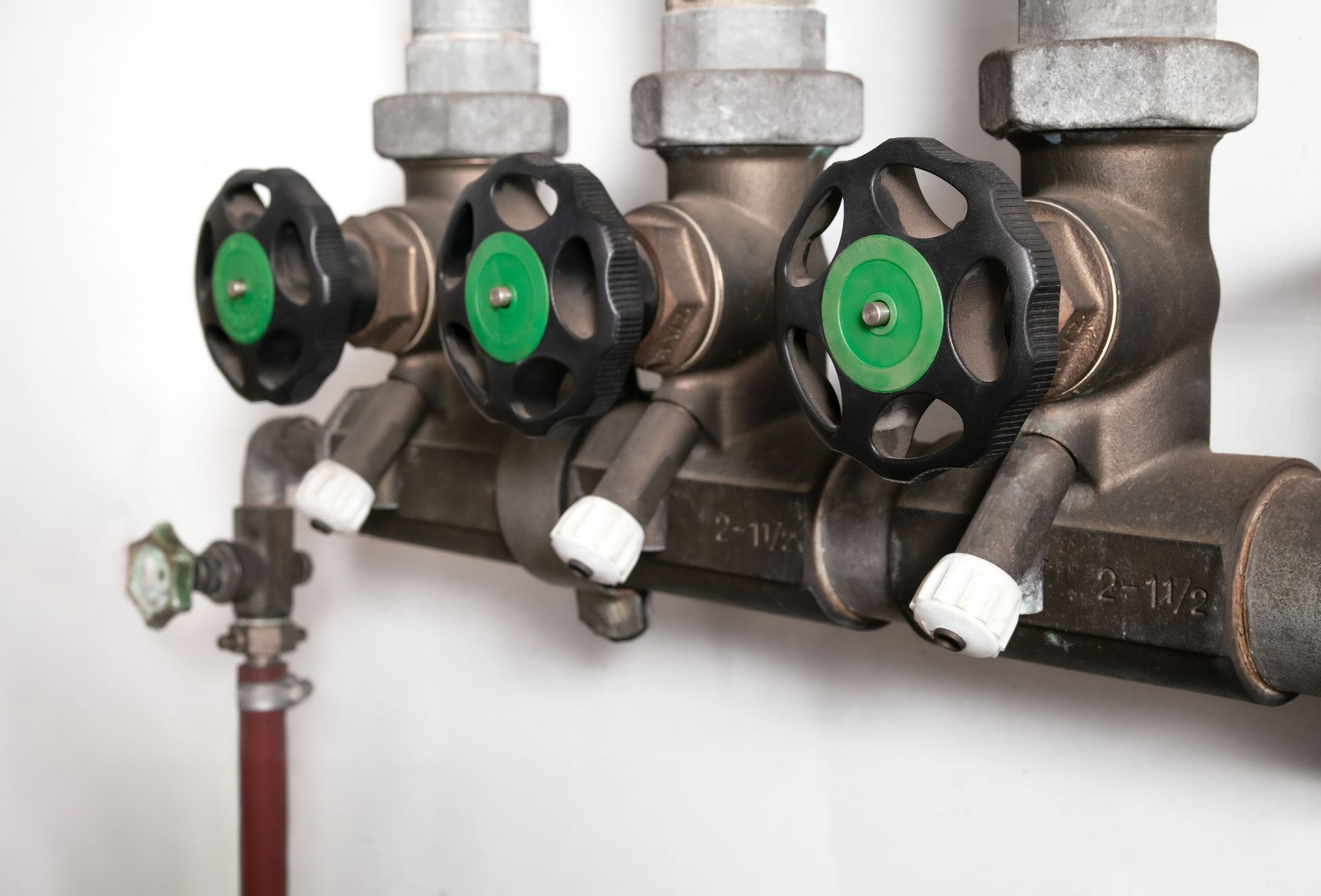 A close up of a pipe with three valves on it