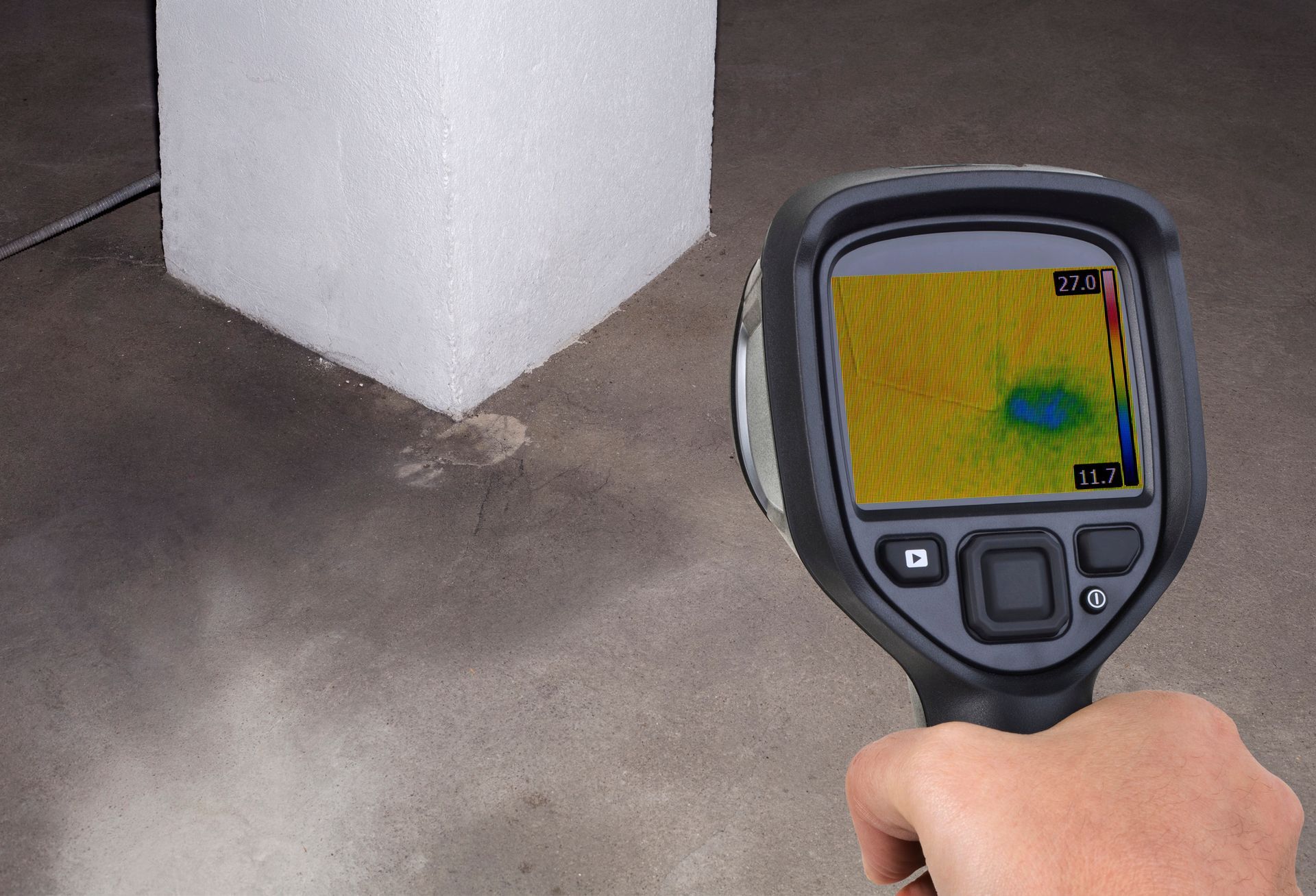 A person is holding a thermal camera in their hand.