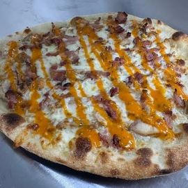 Cheesy pizza on plates at a table, with slices and a soda can nearby