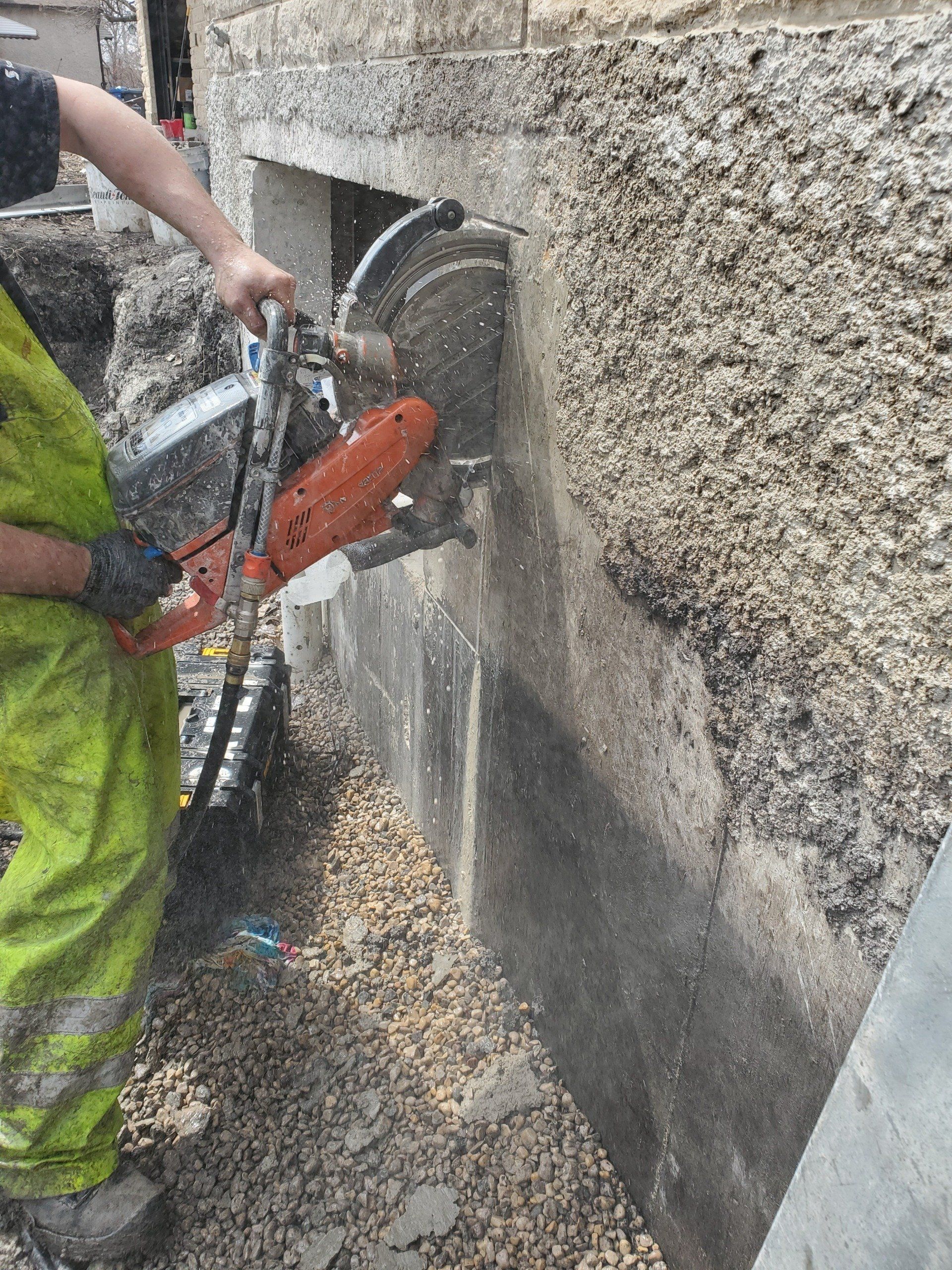A man is cutting a hole in a wall with a circular saw.