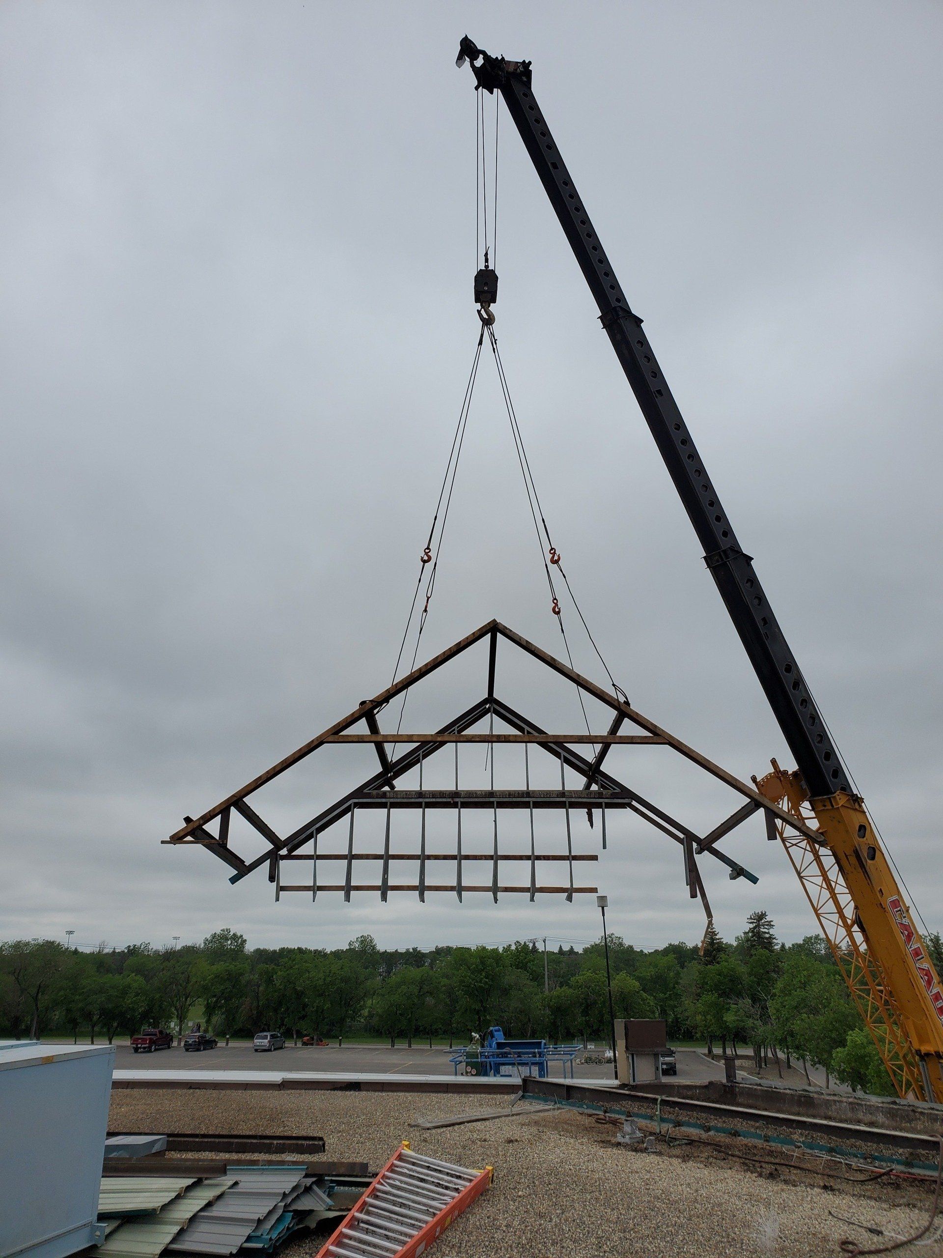 A large crane is lifting a large metal structure