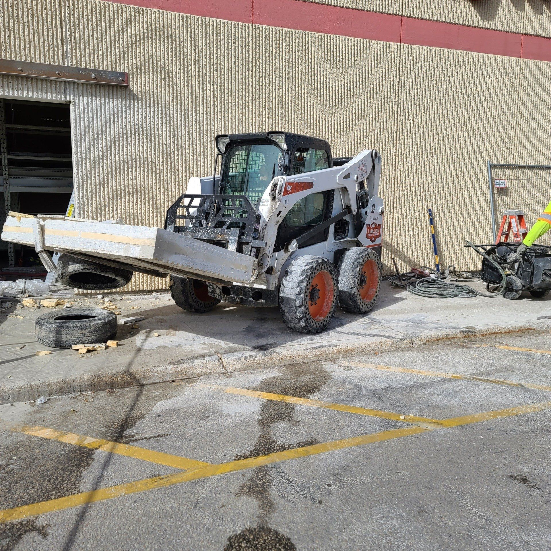 A bobcat skid steer is parked in front of a building