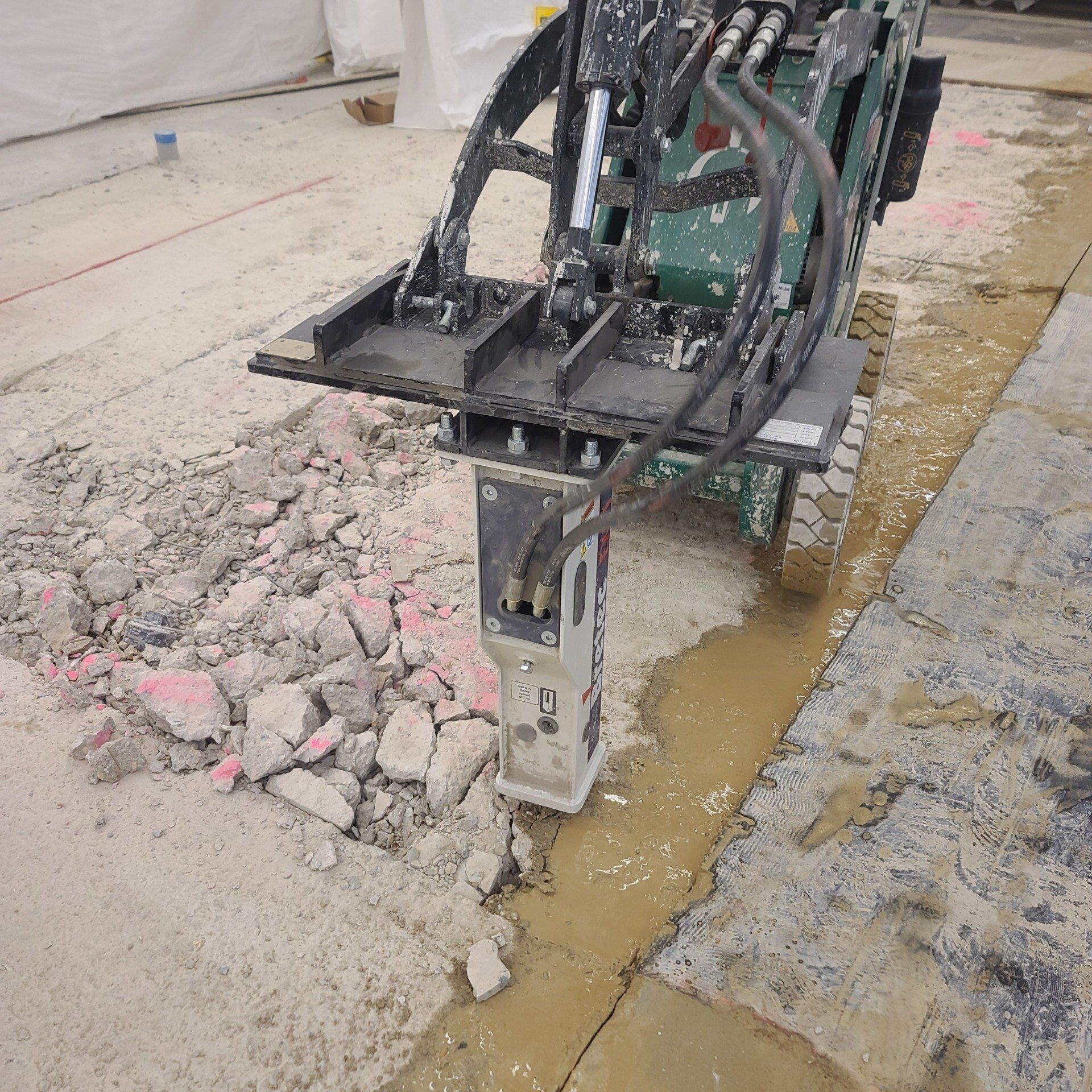 A machine is breaking up concrete on a construction site