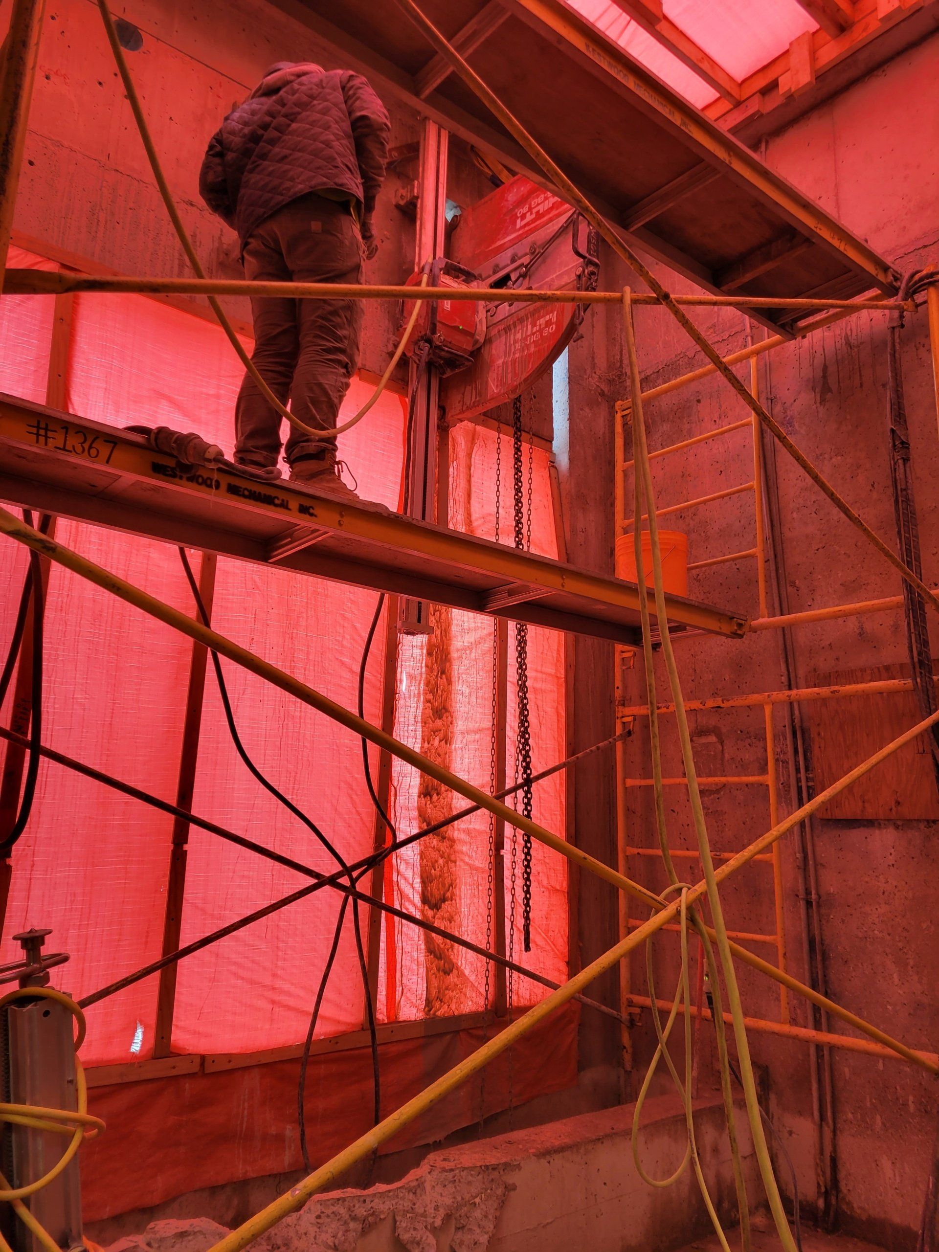 A man is standing on a scaffolding in a building under construction