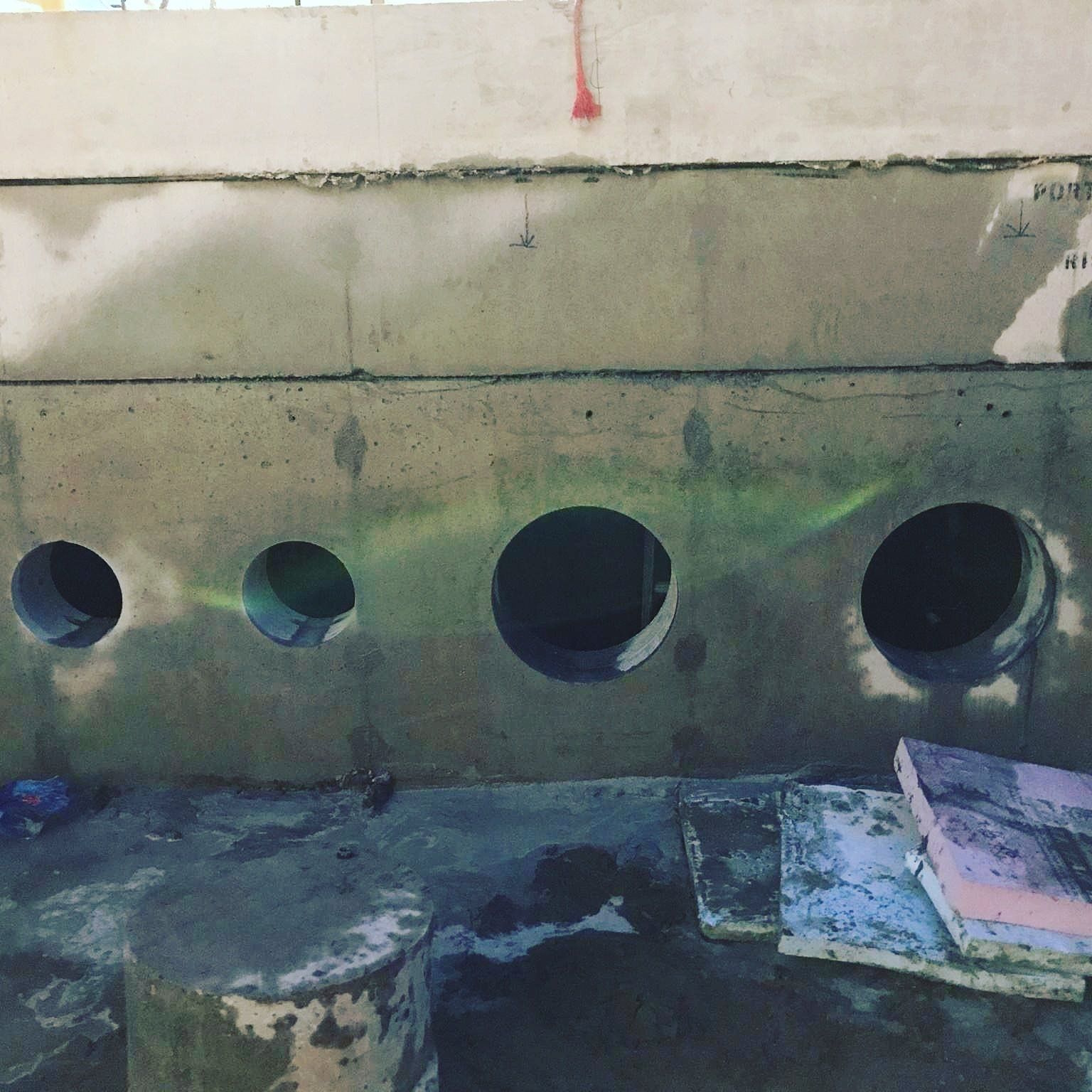 A concrete wall with four holes in it
