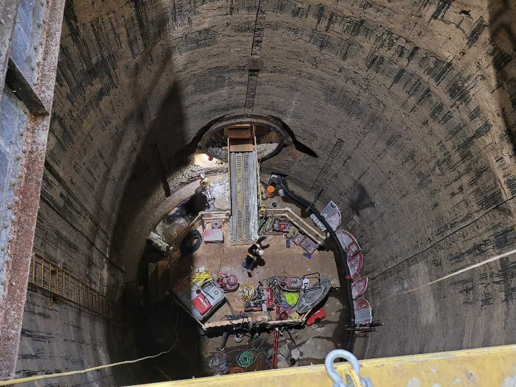 Tunnel interior with machinery and debris visible at the end.