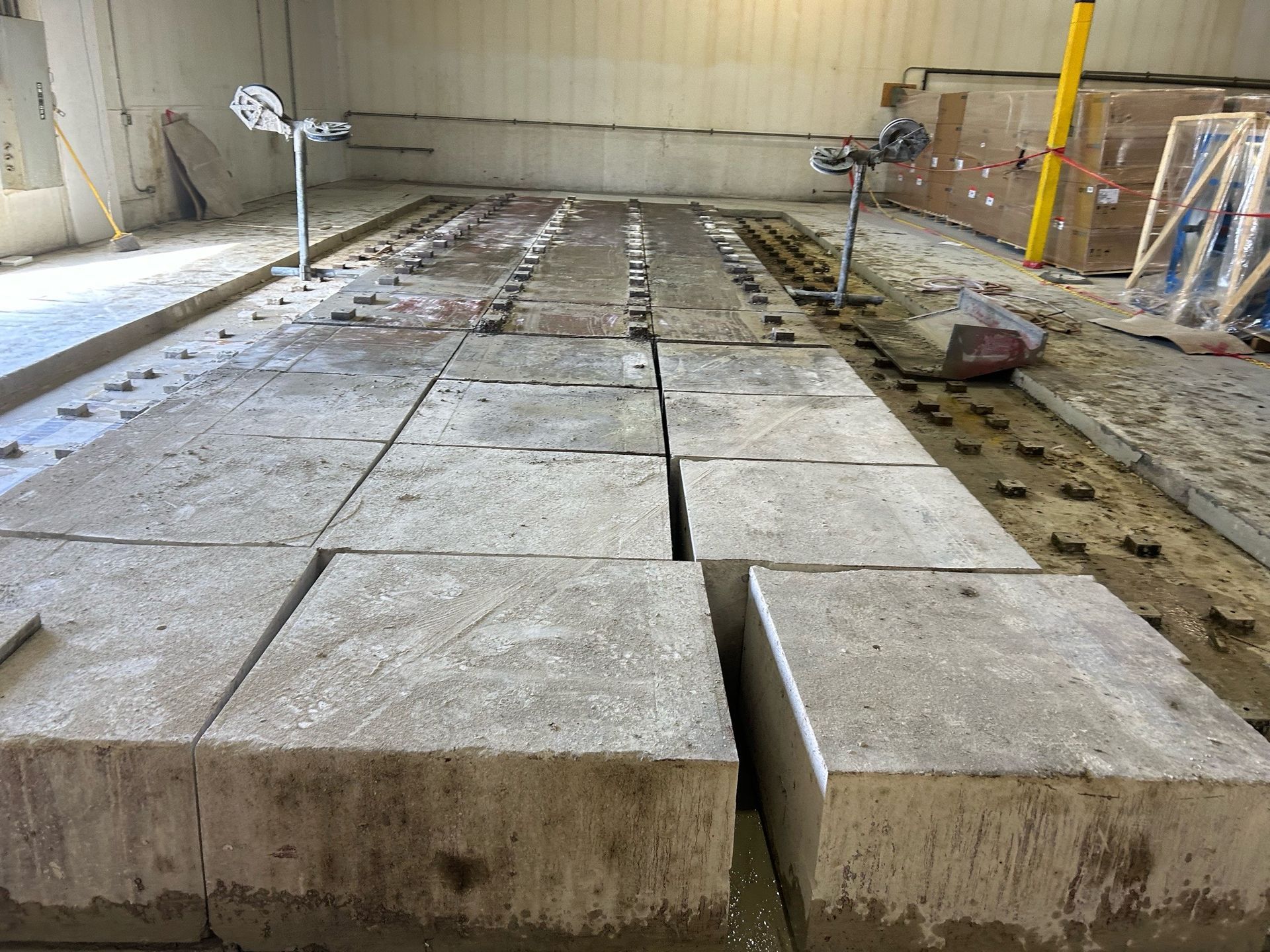 Concrete blocks in rows on a construction site; two levelers are visible.