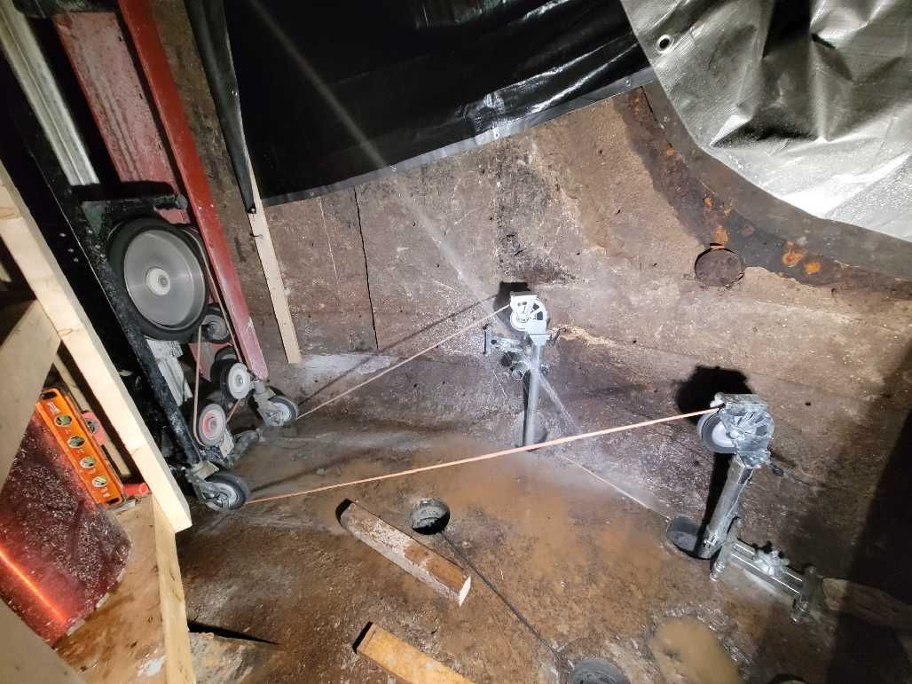 Diamond wire saw cutting a circular concrete structure, dark setting.