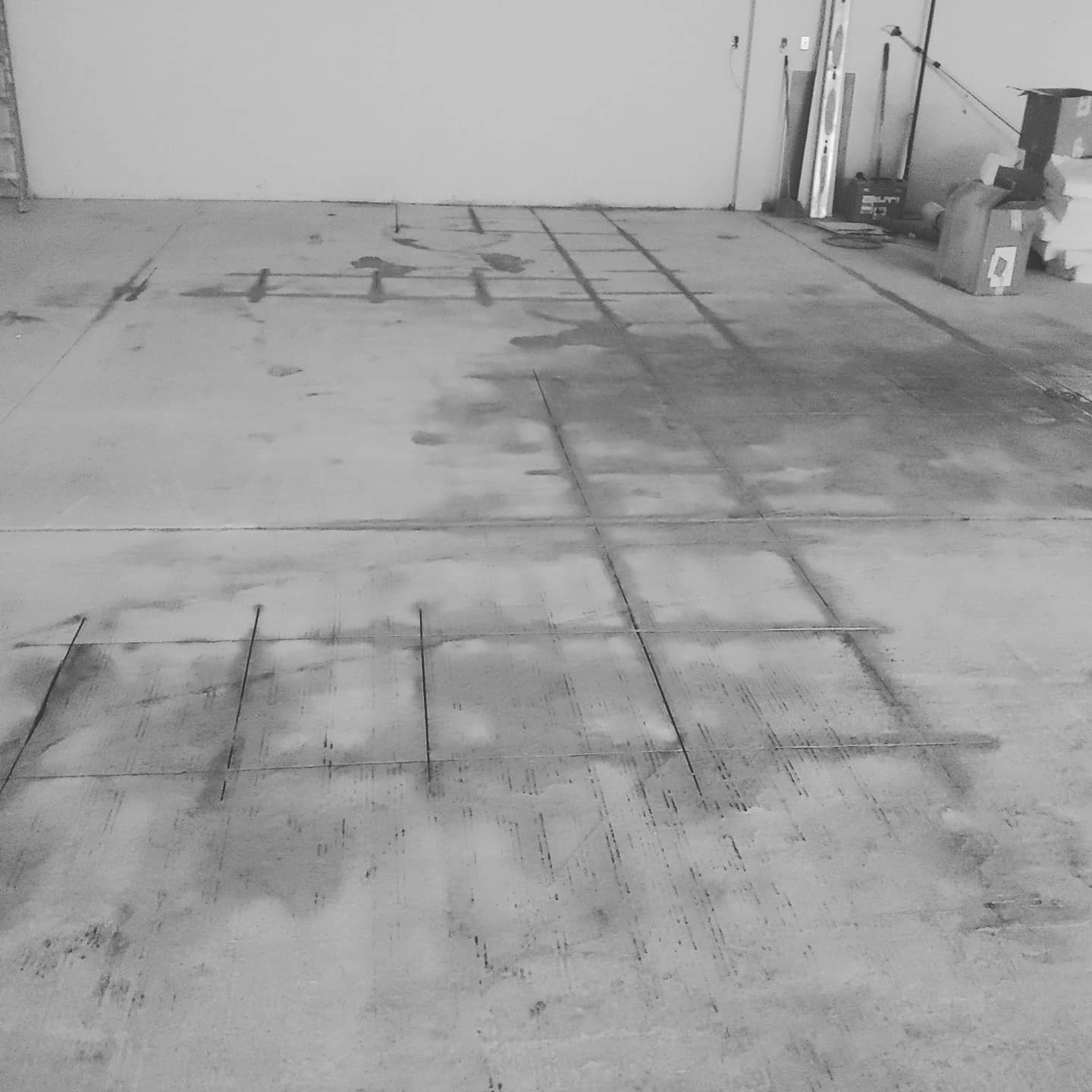 A black and white photo of a concrete floor in a garage.