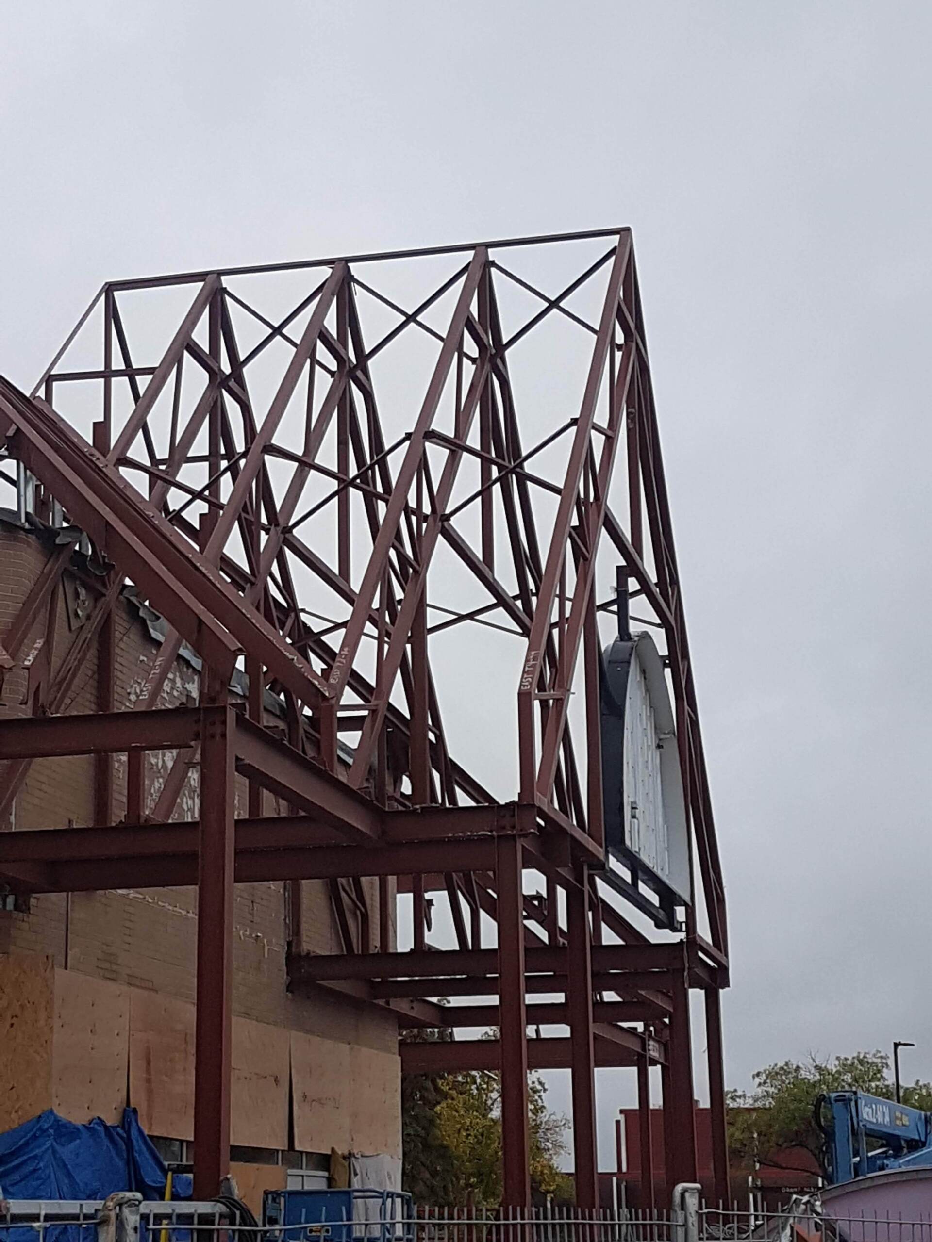 A large metal structure is being built on top of a building.