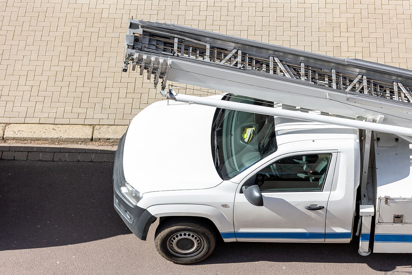 A white truck with a ladder on top of it
