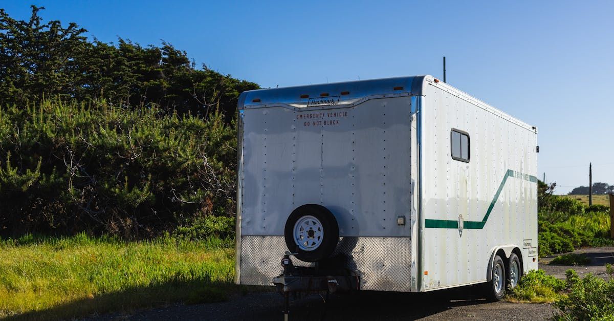 A white trailer is parked on the side of the road