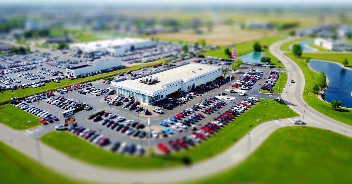 An aerial view of a car dealership with lots of cars parked in front of it