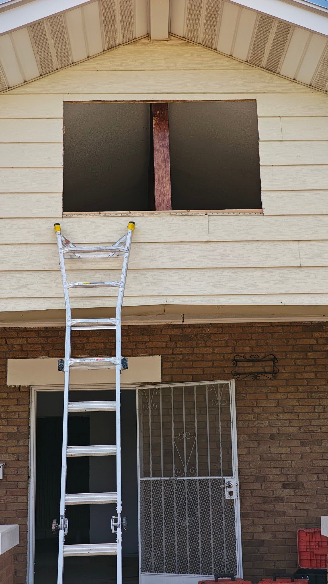 Two-story house front with a ladder reaching an open second-floor window under construction