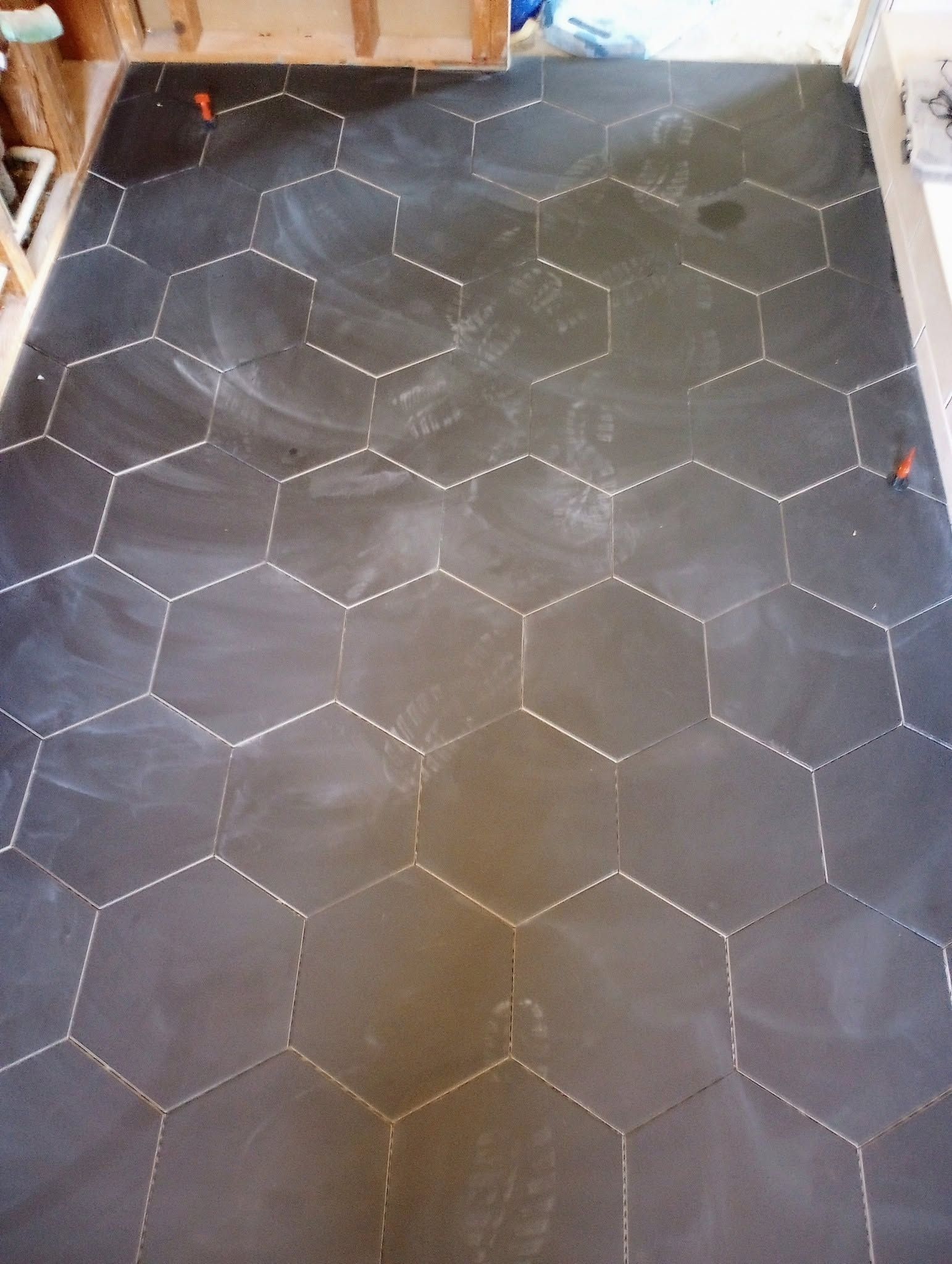 Black tiled floor with a white hexagon pattern, viewed from above.