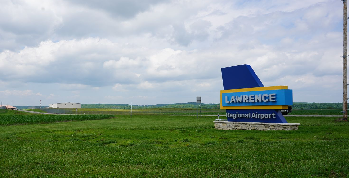 green yard of Lawrence Airport with sign