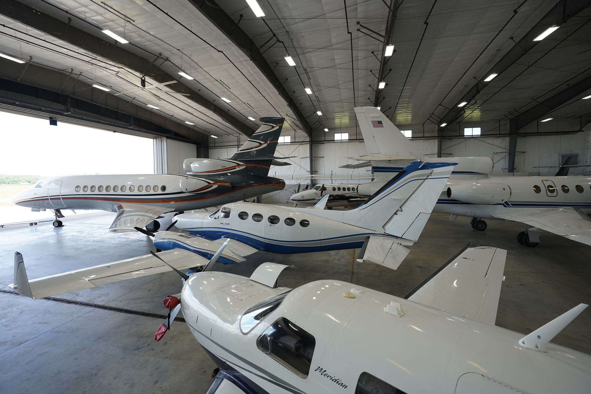 Two private jets are parked in a hangar.