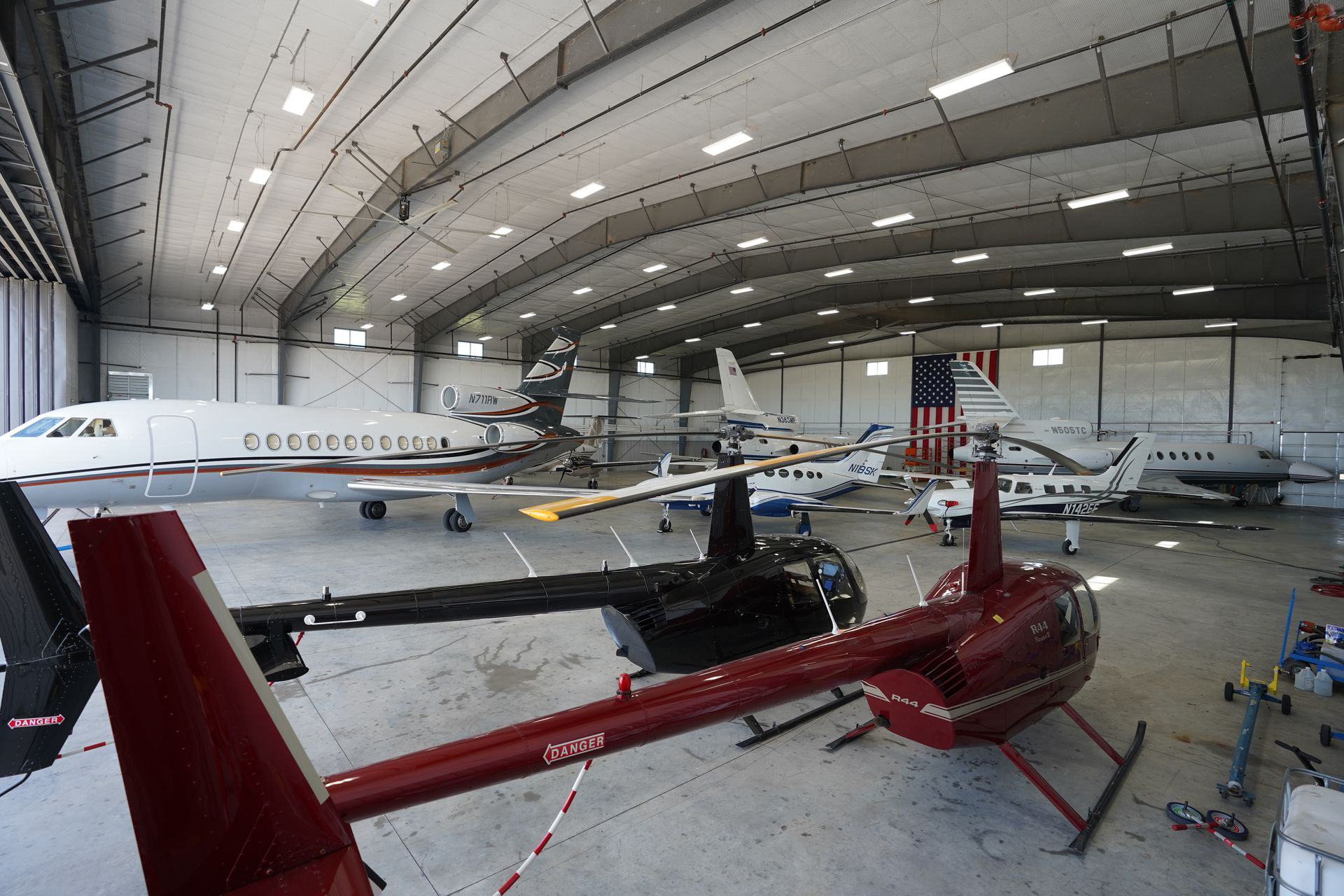 A private jet is parked in a hangar with the door open