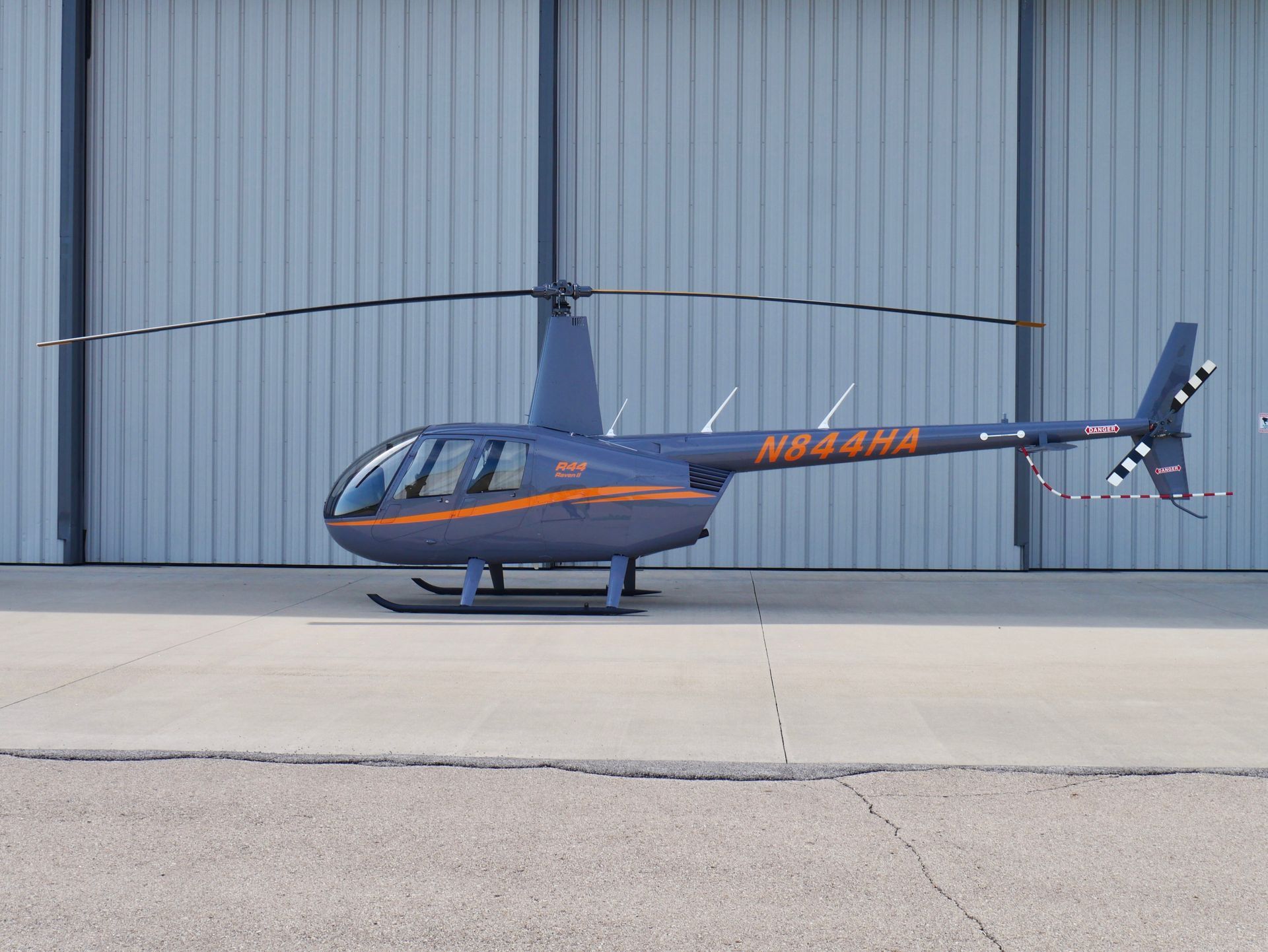 A black helicopter is sitting on a runway in the snow.