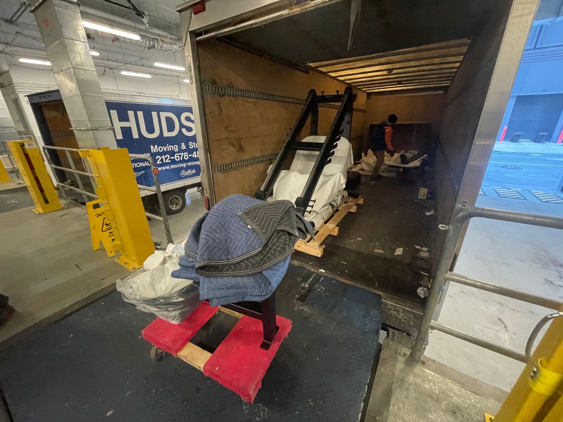 Fitness equipment wrapped and secured for delivery inside a logistics truck.