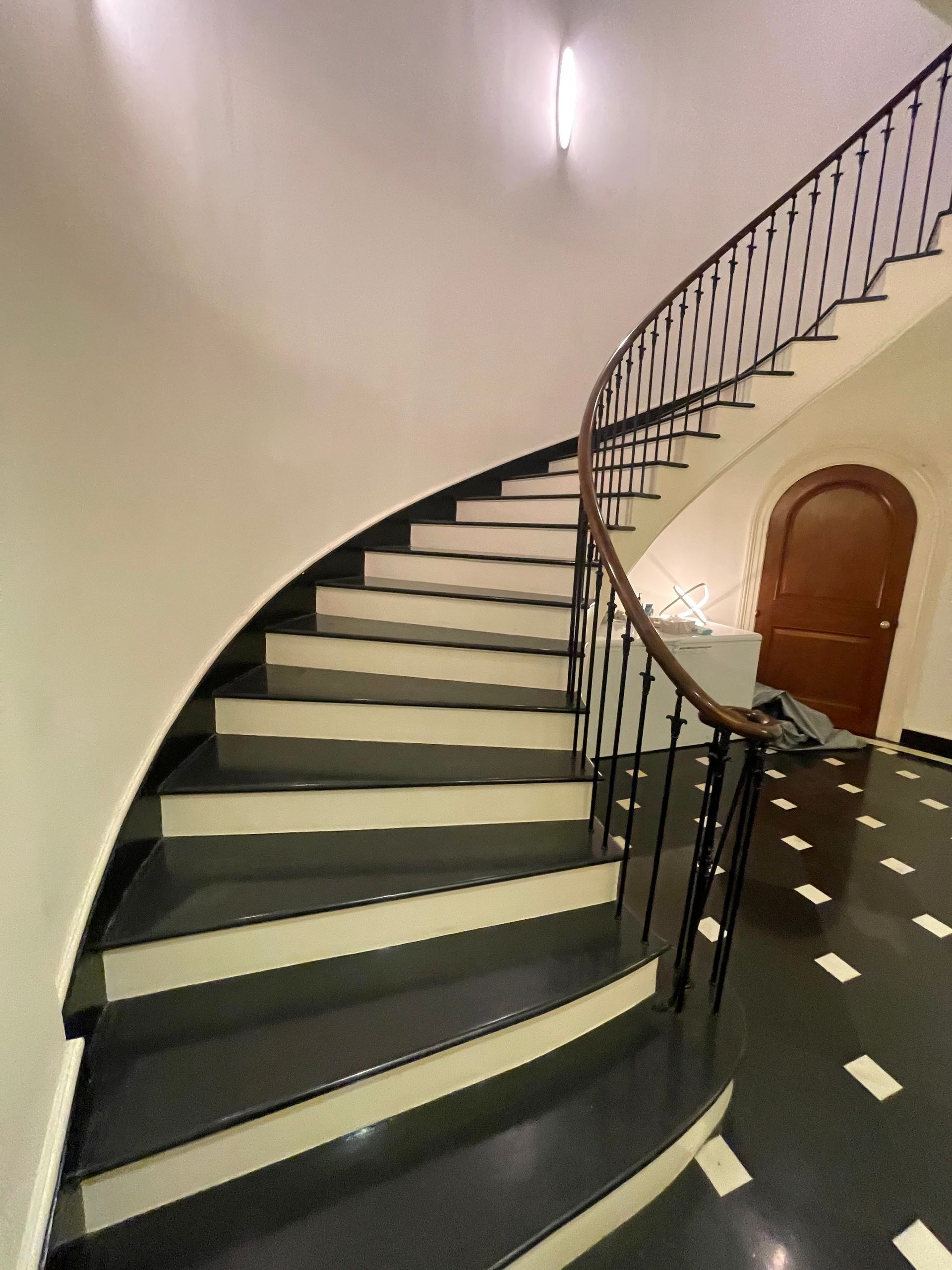 Curved staircase with black railing inside a luxury residential building.
