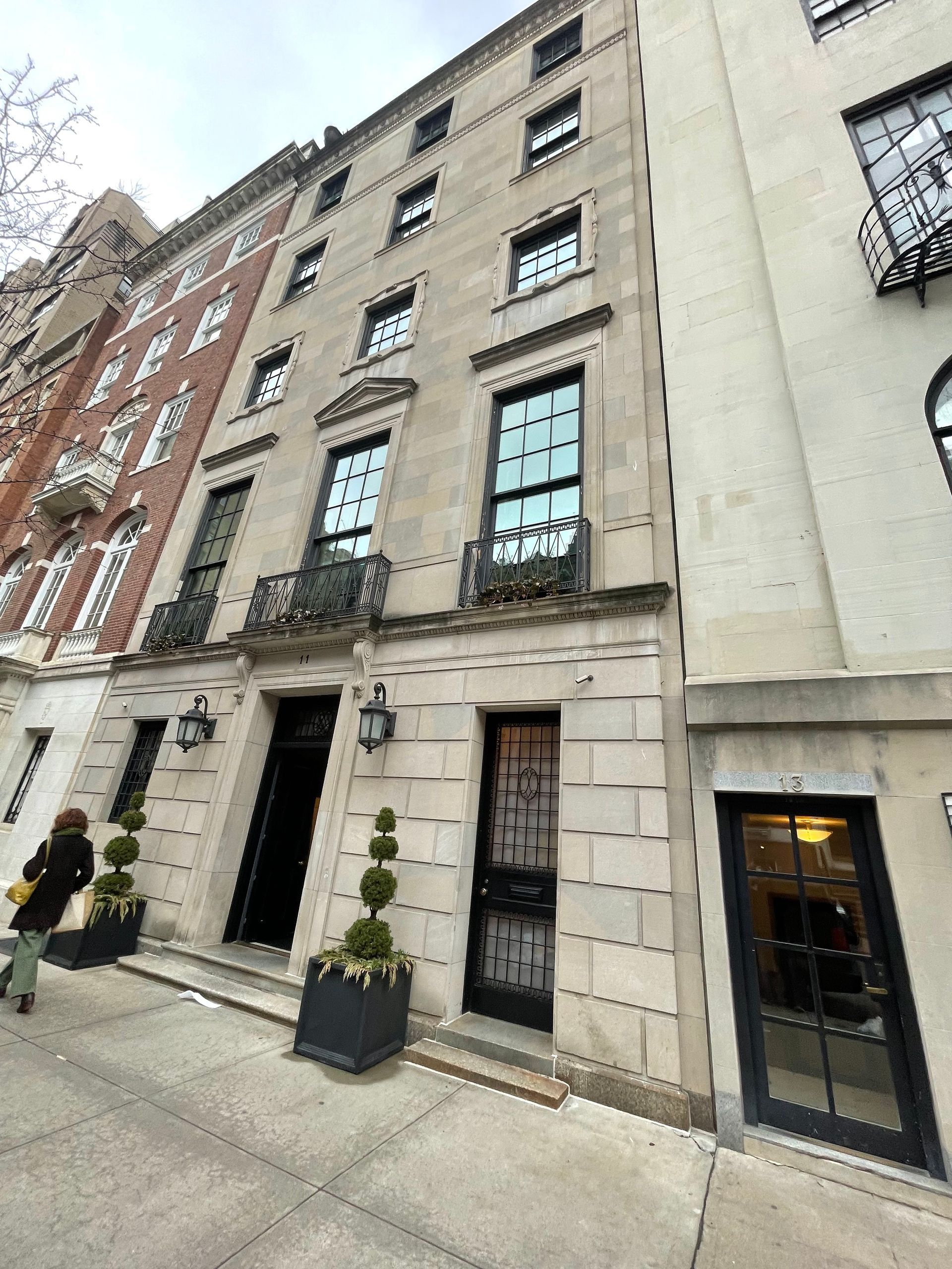 Front facade of an upscale New York City townhouse with detailed stonework.