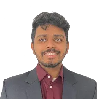 Man in a blazer and burgundy shirt smiles.