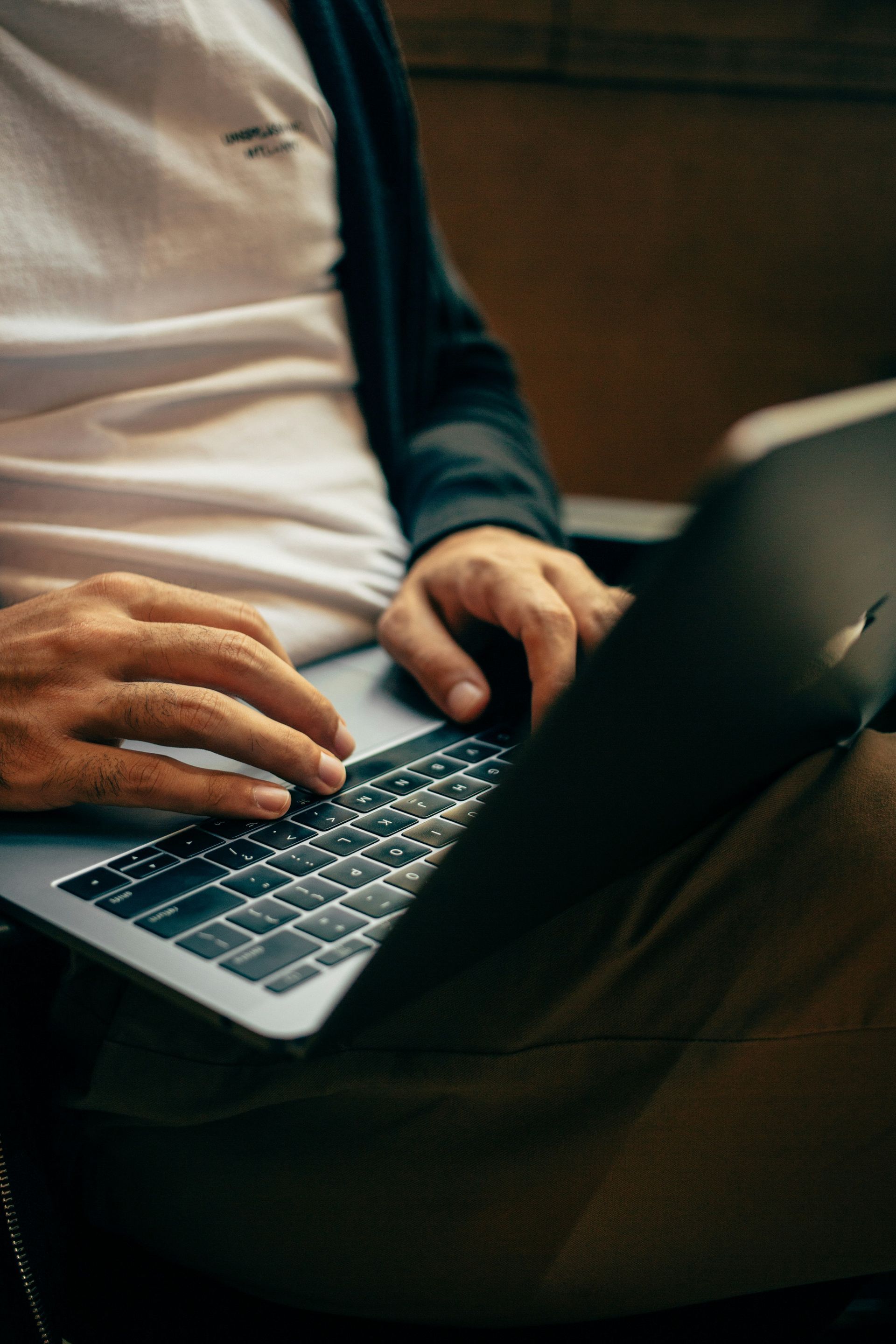 Person typing on a laptop, hands on keyboard.