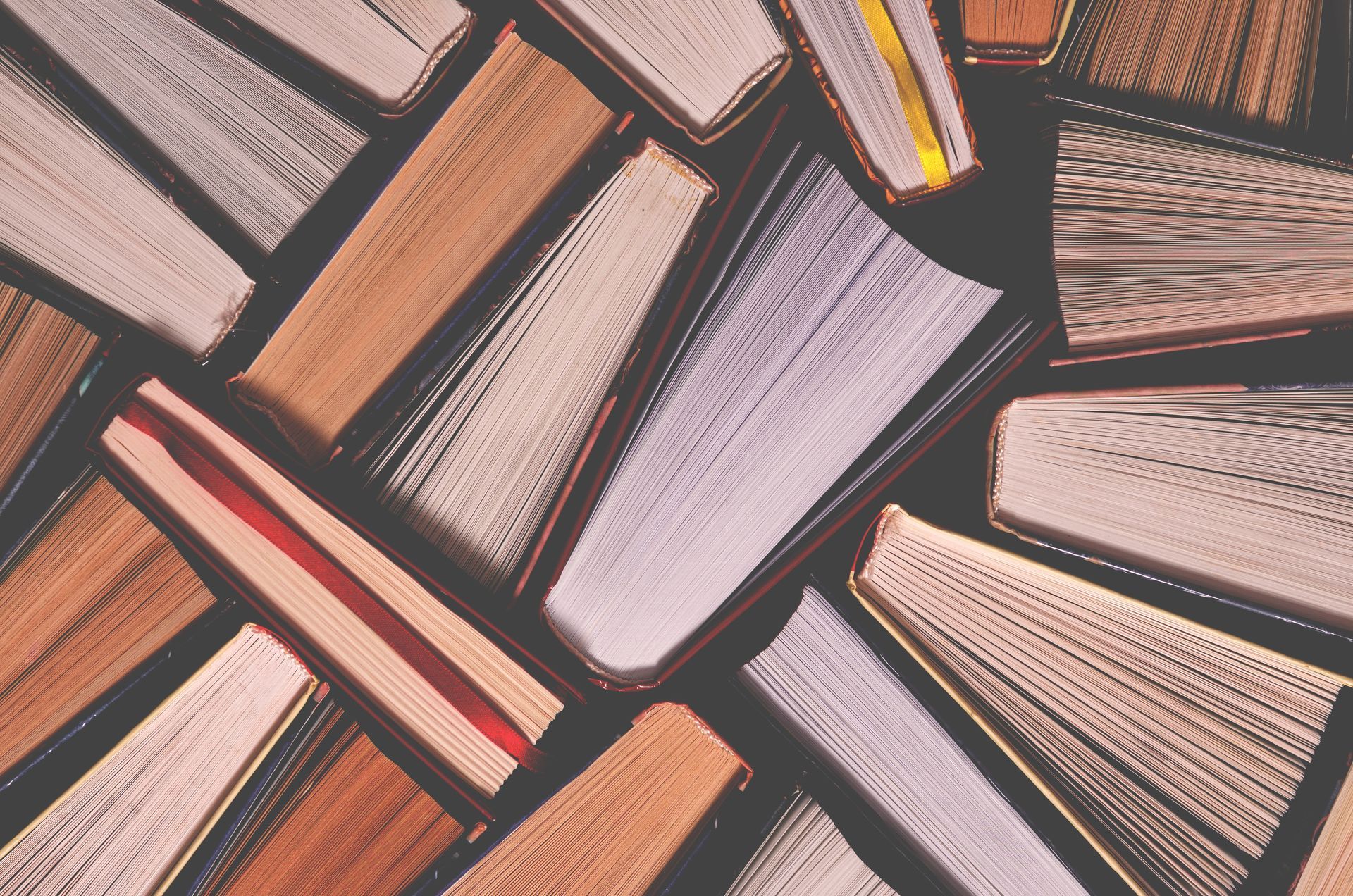 A bunch of books are stacked on top of each other on a table.
