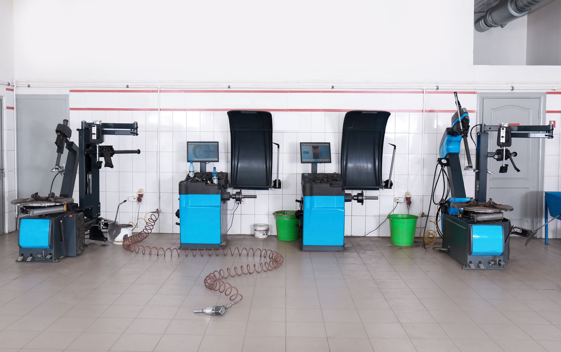 Une rangée de machines d'équilibrage de pneus dans un garage.