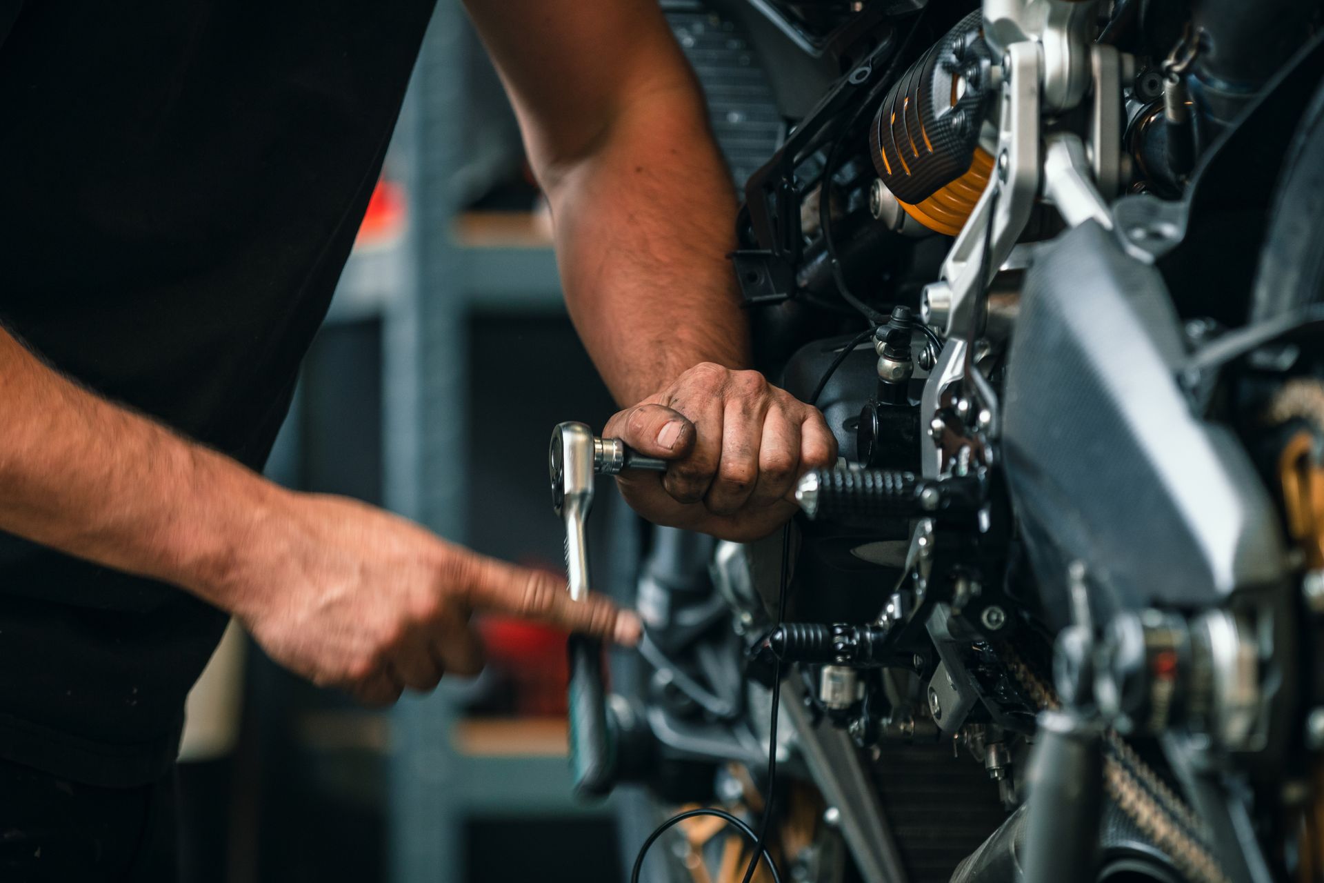 Un homme travaille sur une moto dans un garage.