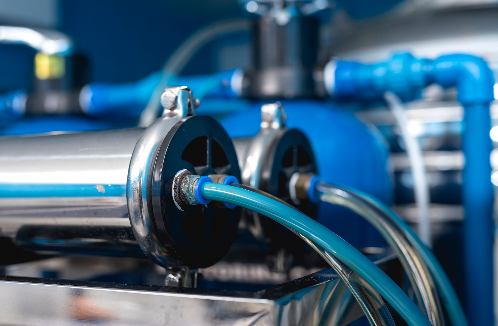 A close up of a machine with blue pipes connected to it.