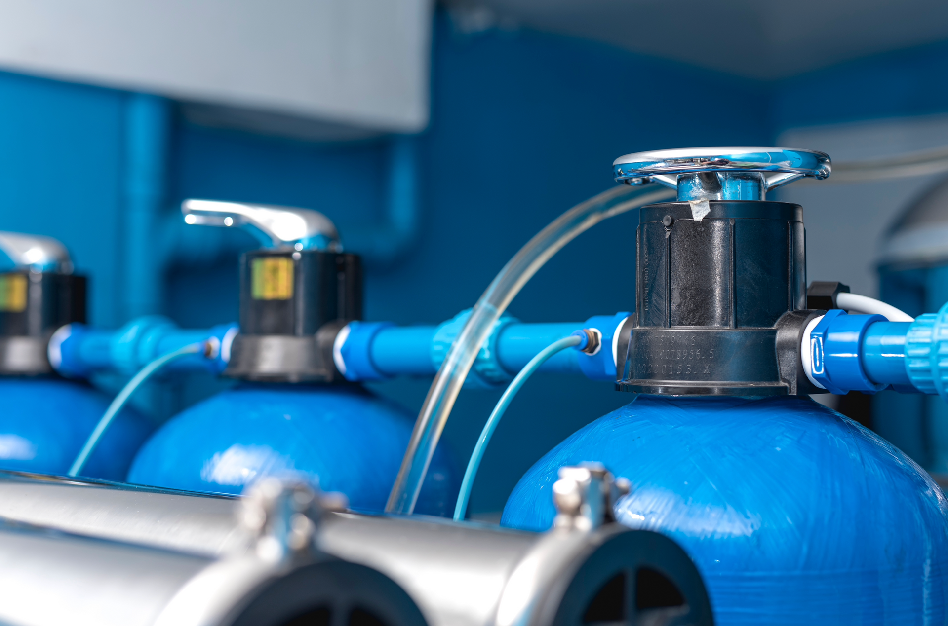 A row of blue tanks with water coming out of them